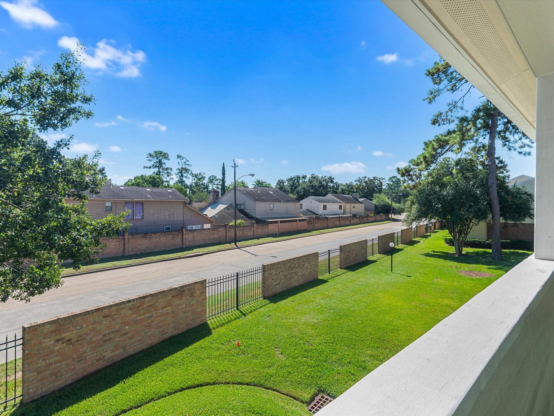 View from the balcony overlooking the landscaped grounds and surrounding neighborhood.