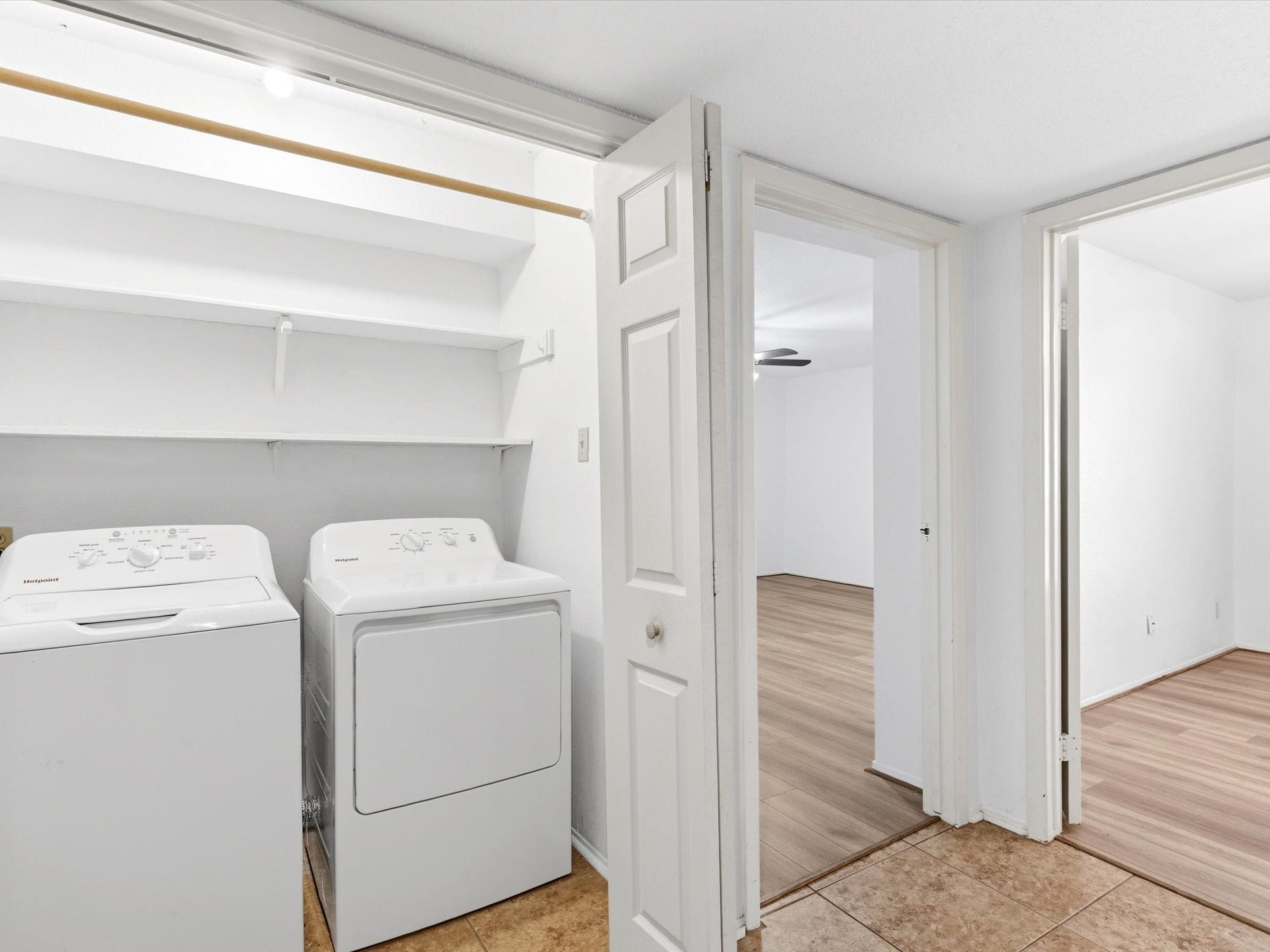 Another view of the laundry area, highlighting the storage space and easy access to the hallway.
