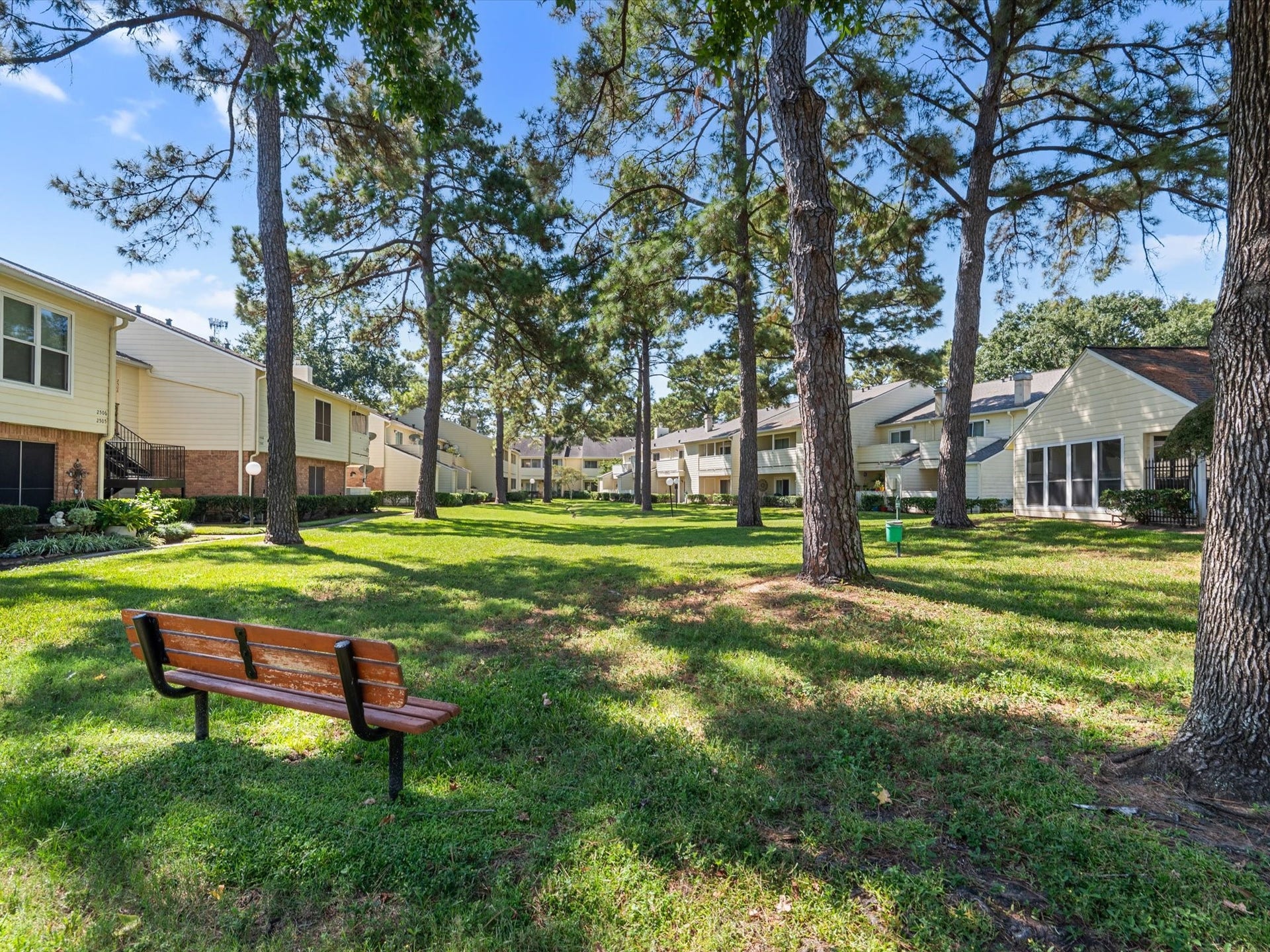 Shaded green space with a bench, offering a peaceful spot to enjoy the outdoors.