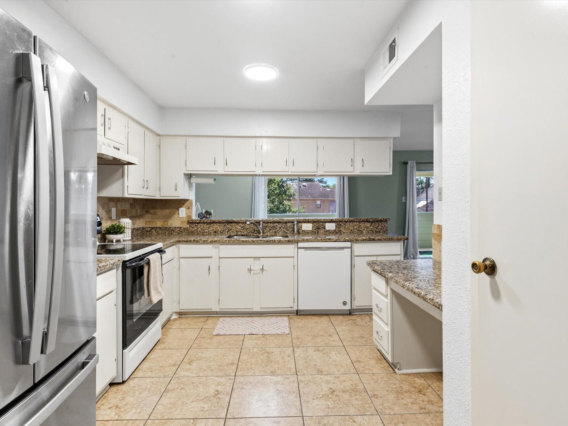 Bright kitchen with plenty of cabinet space and a window overlooking the outdoors.