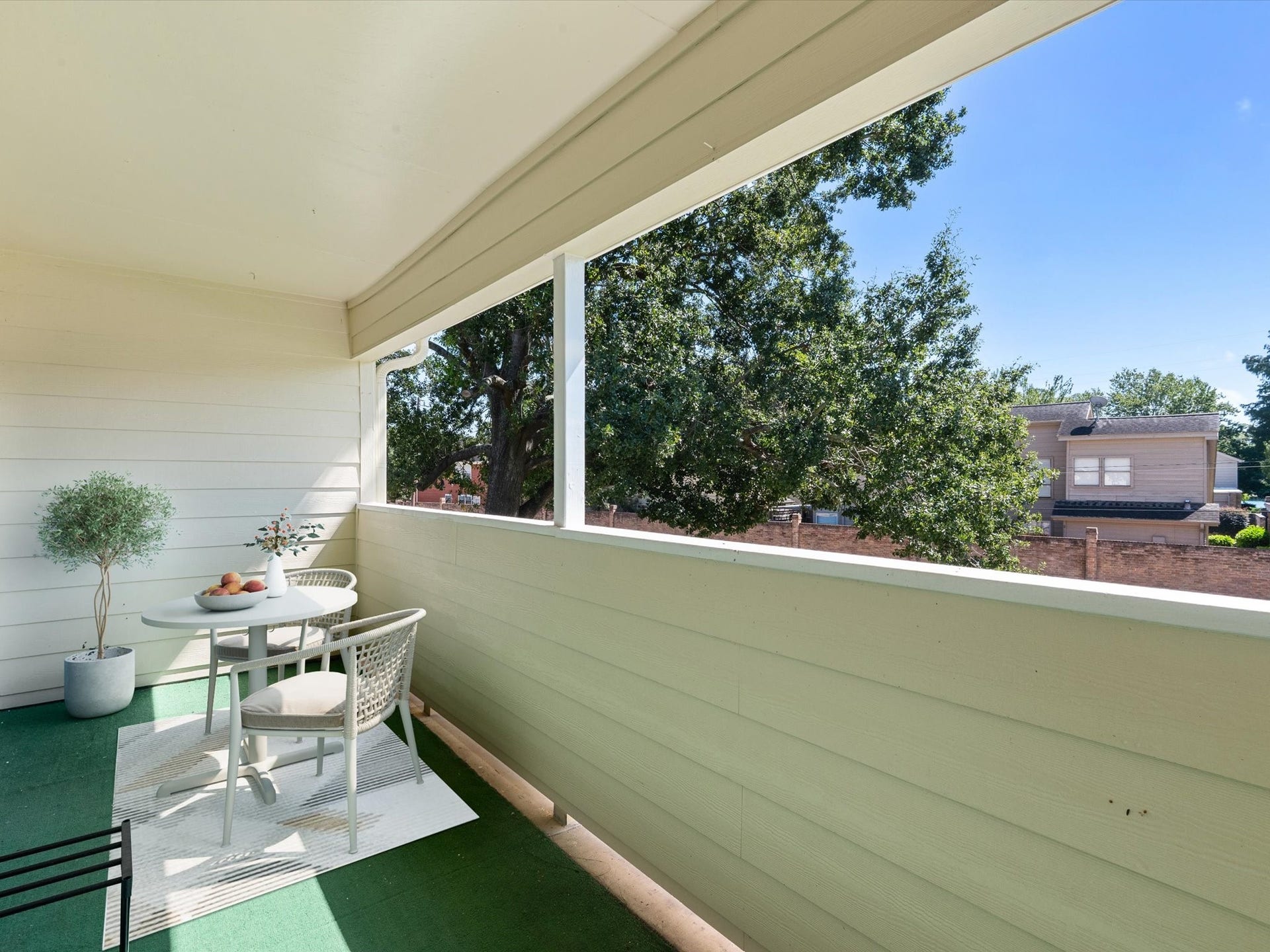 Staged balcony with an open view of the surrounding greenery.