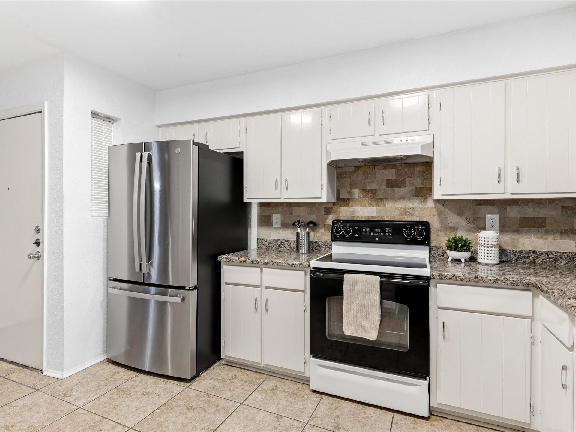 Another view of the kitchen, highlighting the white cabinetry and generous counter space.