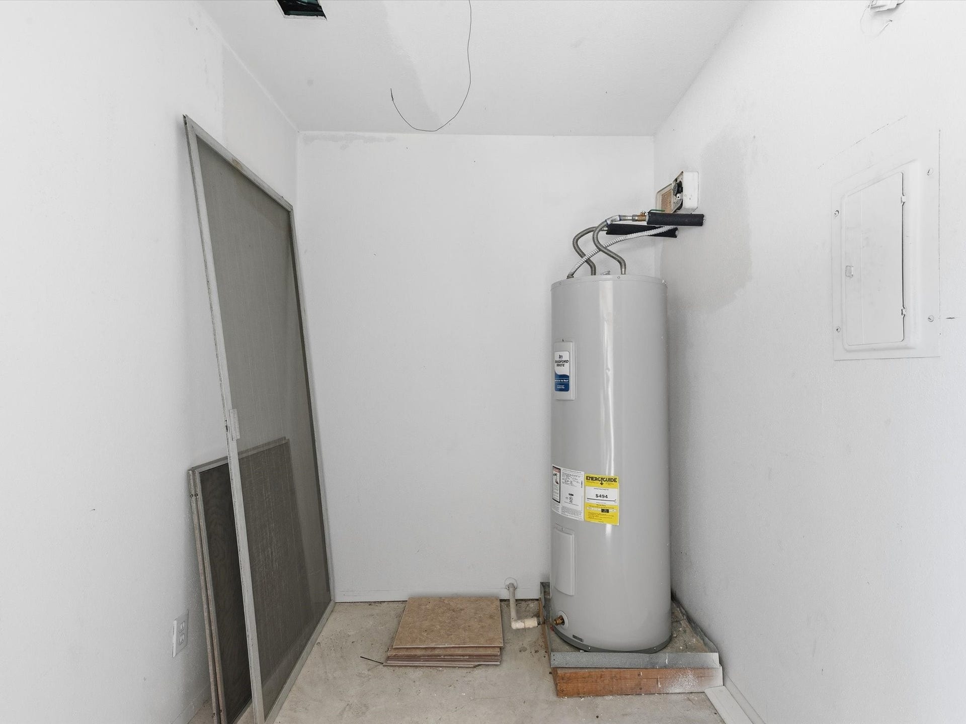 Additional storage area with a water heater and room for household essentials.