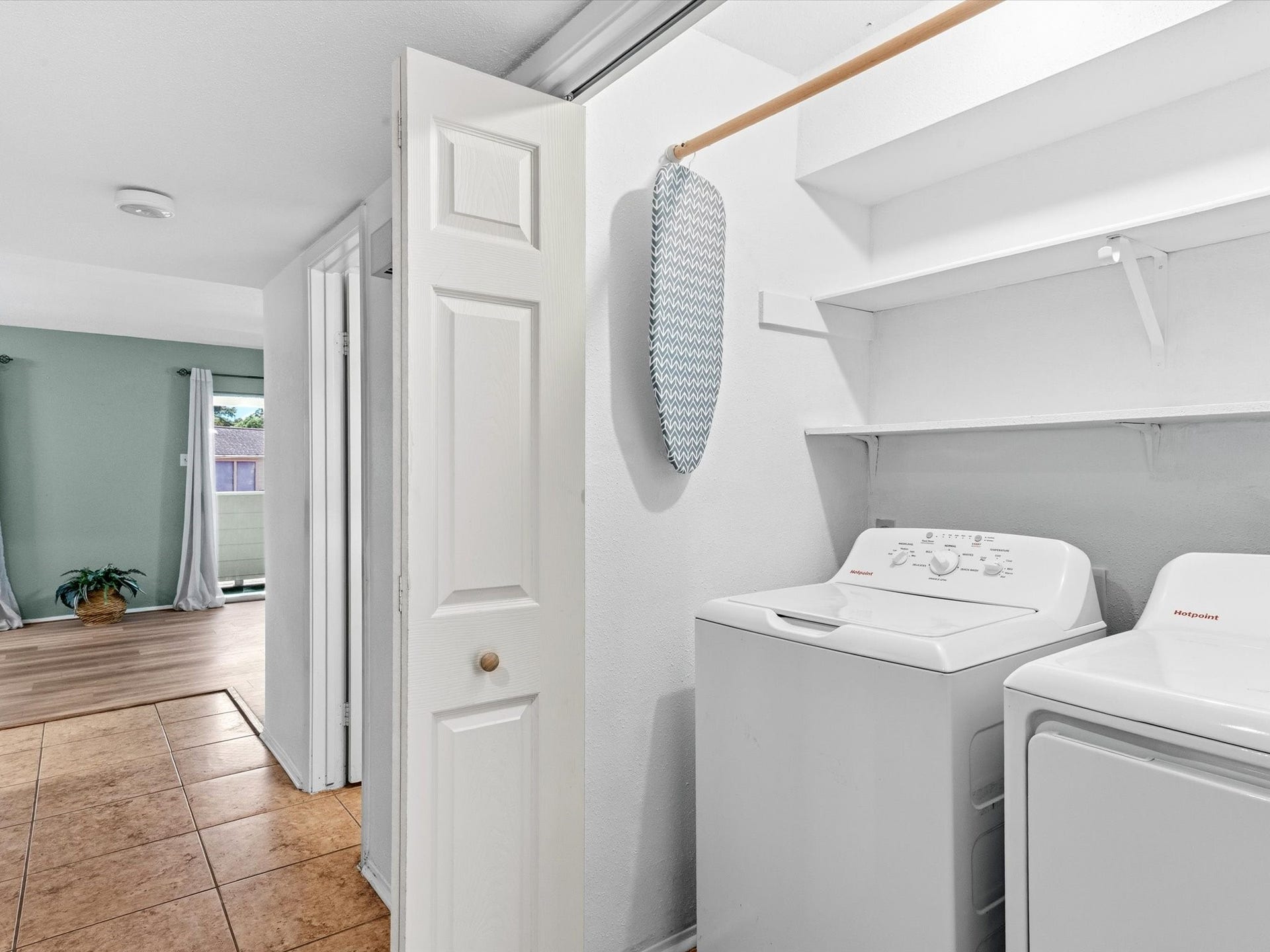 Convenient laundry area with built-in shelving for additional storage.