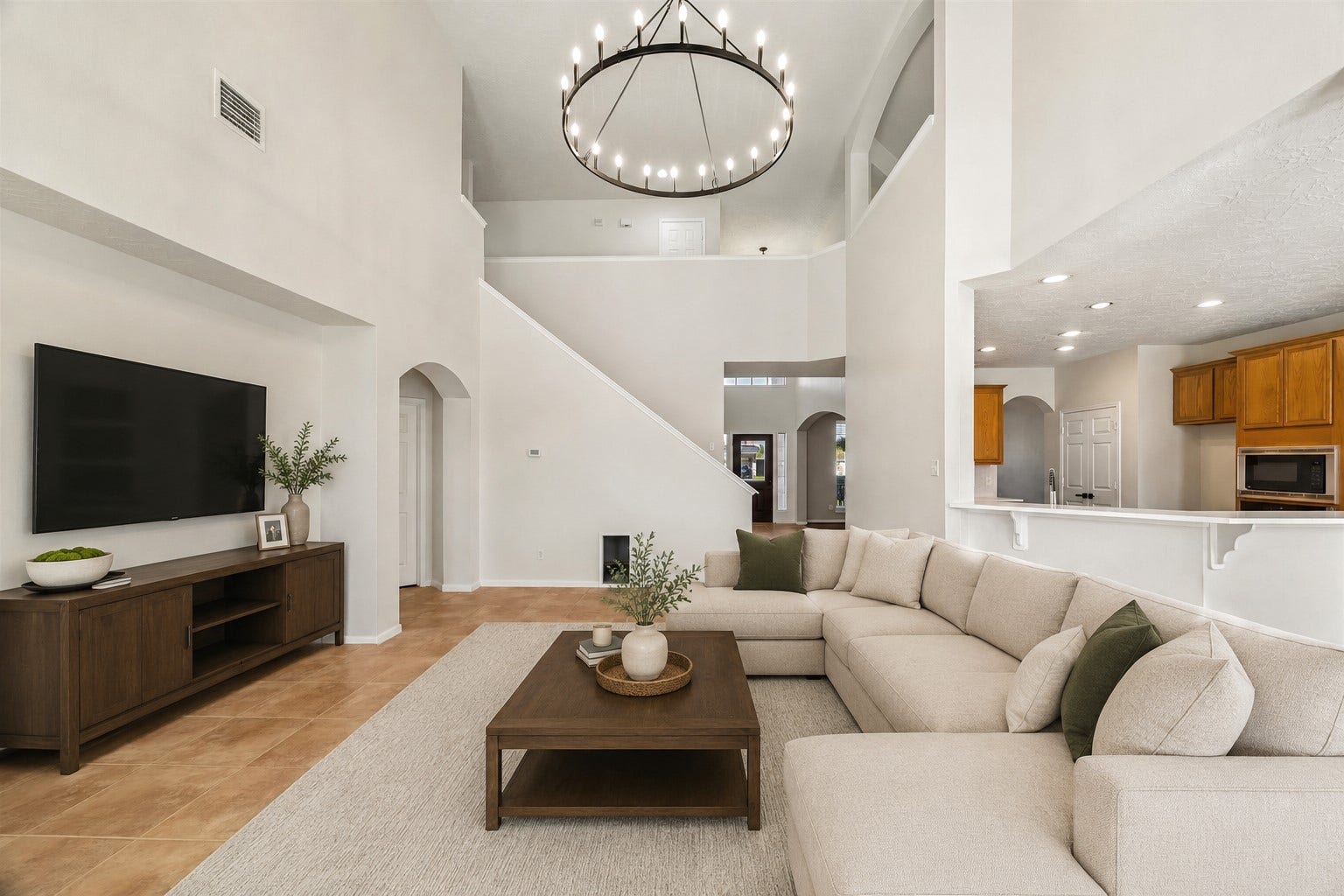 8126 BUFFALO SPRINGS COURT, Sugar Land, TX 77479 DRAMATIC TWO-STORY LIVING AREA WITH SOARING CEILINGS, AN OVERSIZED STATEMENT LIGHT FIXTURE, AND AN OPEN-CONCEPT CONNECTION TO THE KITCHEN. *Virtually staged. *Virtually staged.