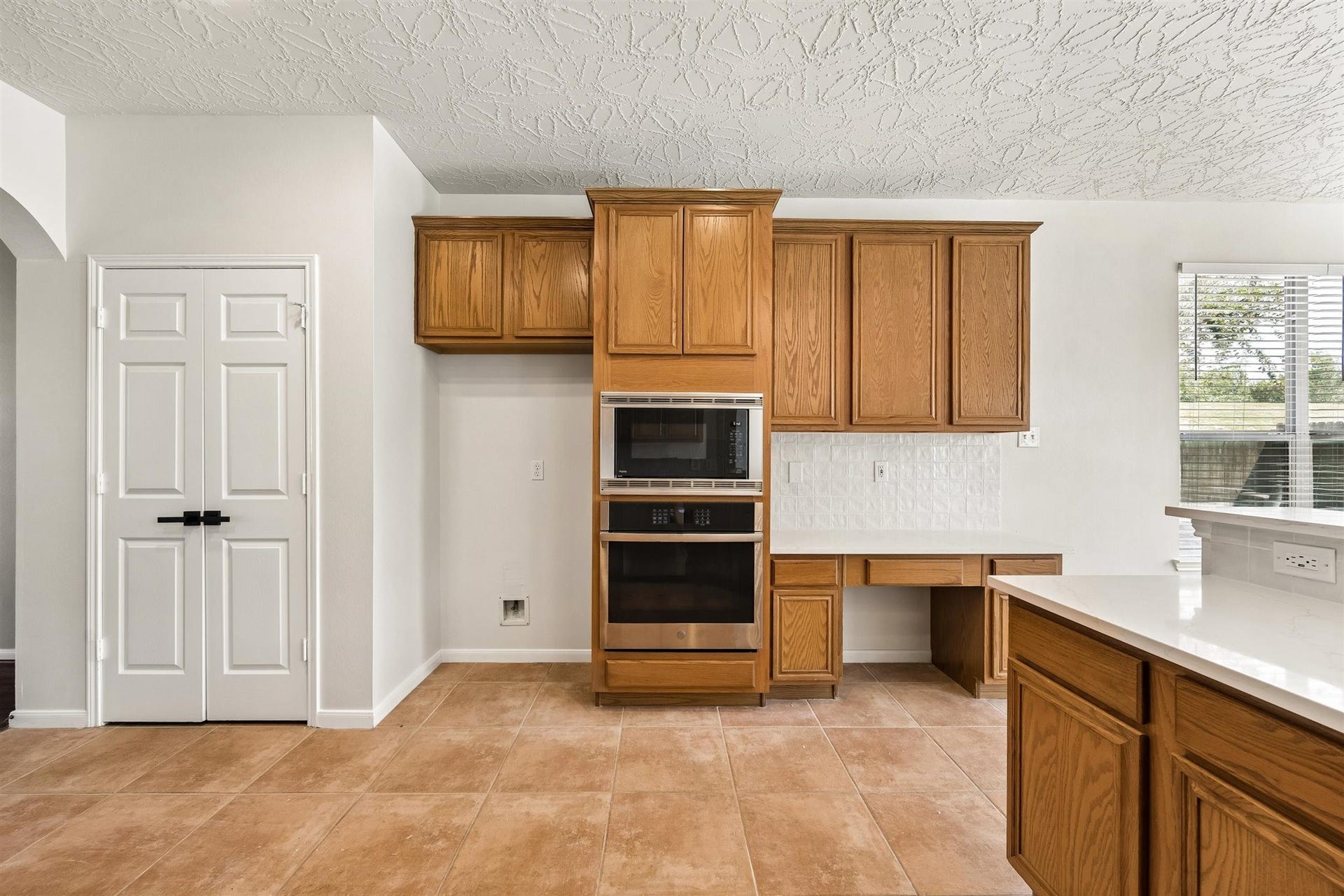 8126 BUFFALO SPRINGS COURT, Sugar Land, TX 77479 WELL-APPOINTED KITCHEN FEATURING WHITE COUNTERTOPS, STAINLESS STEEL APPLIANCES, A GAS COOKTOP, AND ABUNDANT CABINET STORAGE.