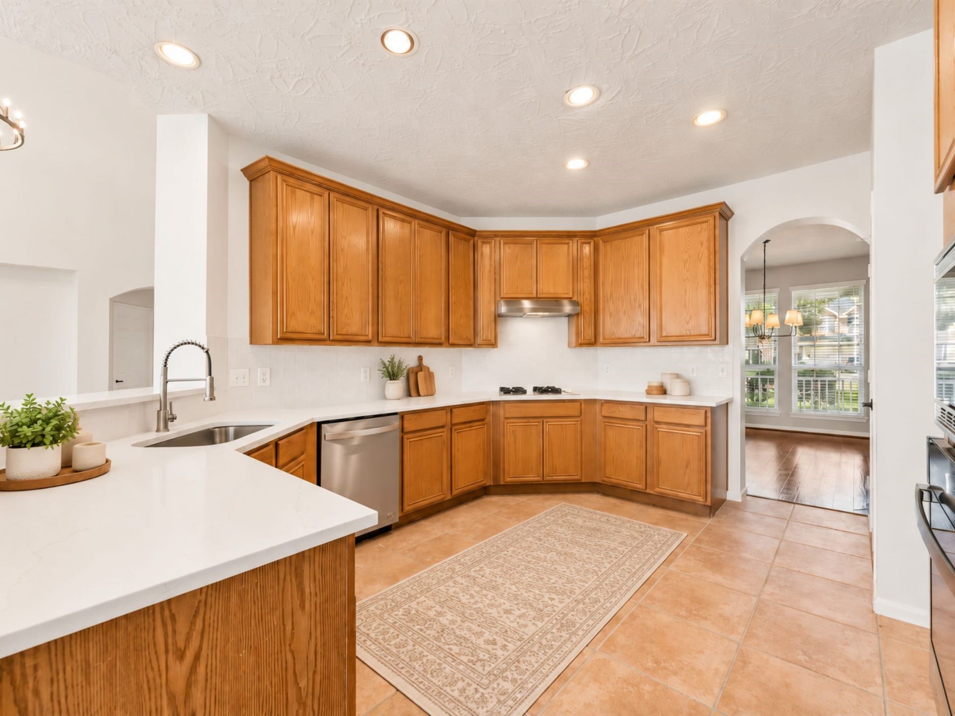 8126 BUFFALO SPRINGS COURT, Sugar Land, TX 77479 GENEROUS KITCHEN OFFERS EXTENSIVE PREP SPACE, BUILT-IN APPLIANCES, A GAS COOKTOP, AND A LARGE PENINSULA.
