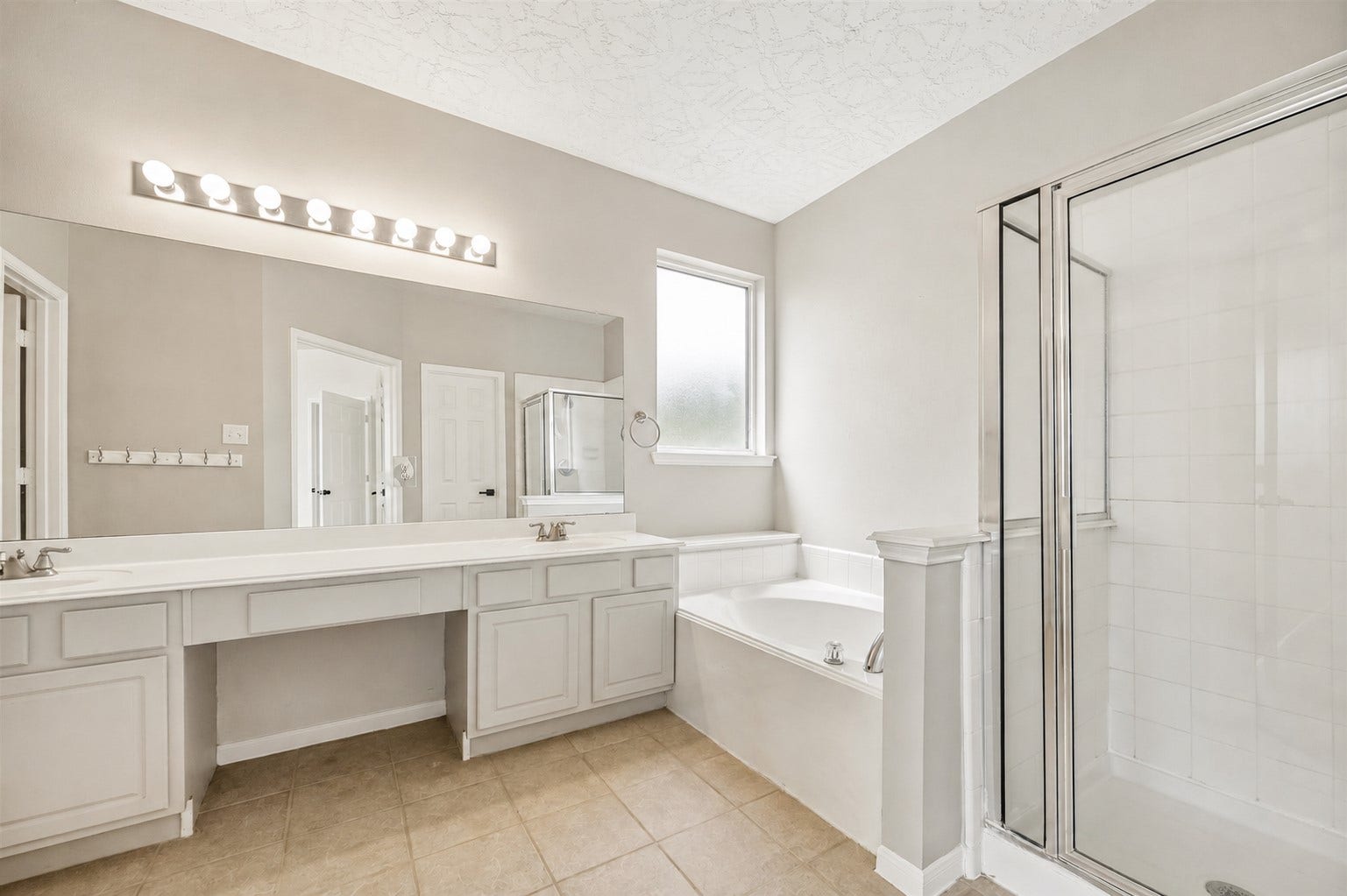 8126 BUFFALO SPRINGS COURT, Sugar Land, TX 77479 PRIMARY BATH FEATURES AN EXTENDED VANITY, DEEP SOAKING TUB, AND SEPARATE GLASS-ENCLOSED SHOWER.