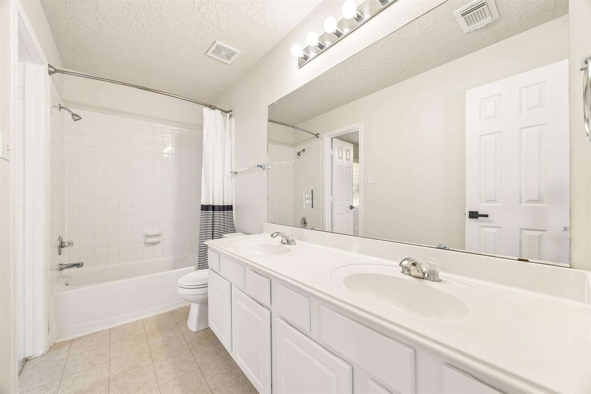8126 BUFFALO SPRINGS COURT, Sugar Land, TX 77479 SECONDARY BATH FEATURES A DOUBLE-SINK VANITY, LARGE MIRROR, AND SEPARATE TUB AND SHOWER AREA.