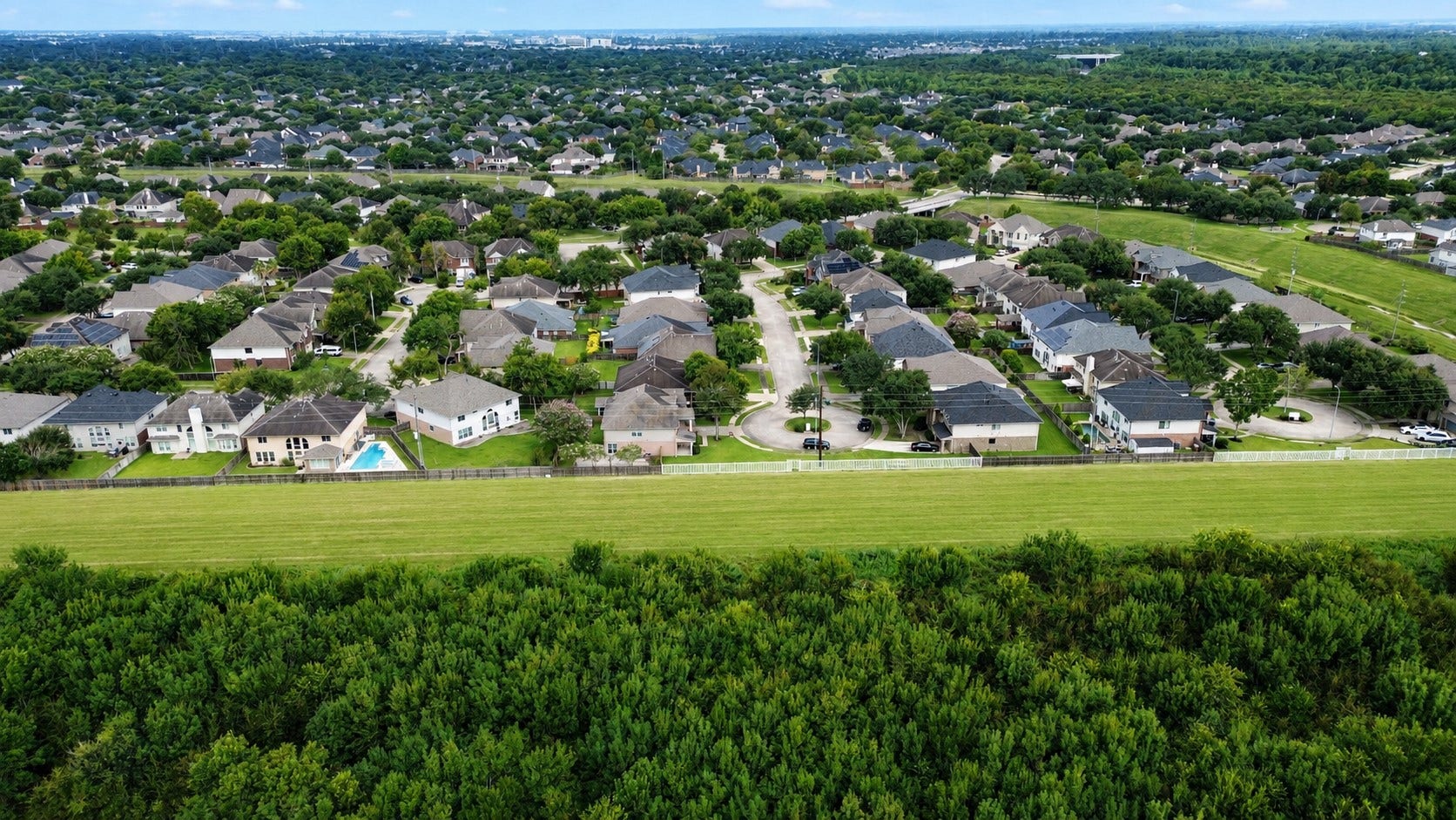 8126 BUFFALO SPRINGS COURT, Sugar Land, TX 77479 SWEEPING AERIAL VIEW OF GREATWOOD SPRINGFIELD SHOWCASES THE ESTABLISHED NEIGHBORHOOD, TREE-LINED STREETS, AND EXPANSIVE LEVEE GREENSPACE.
