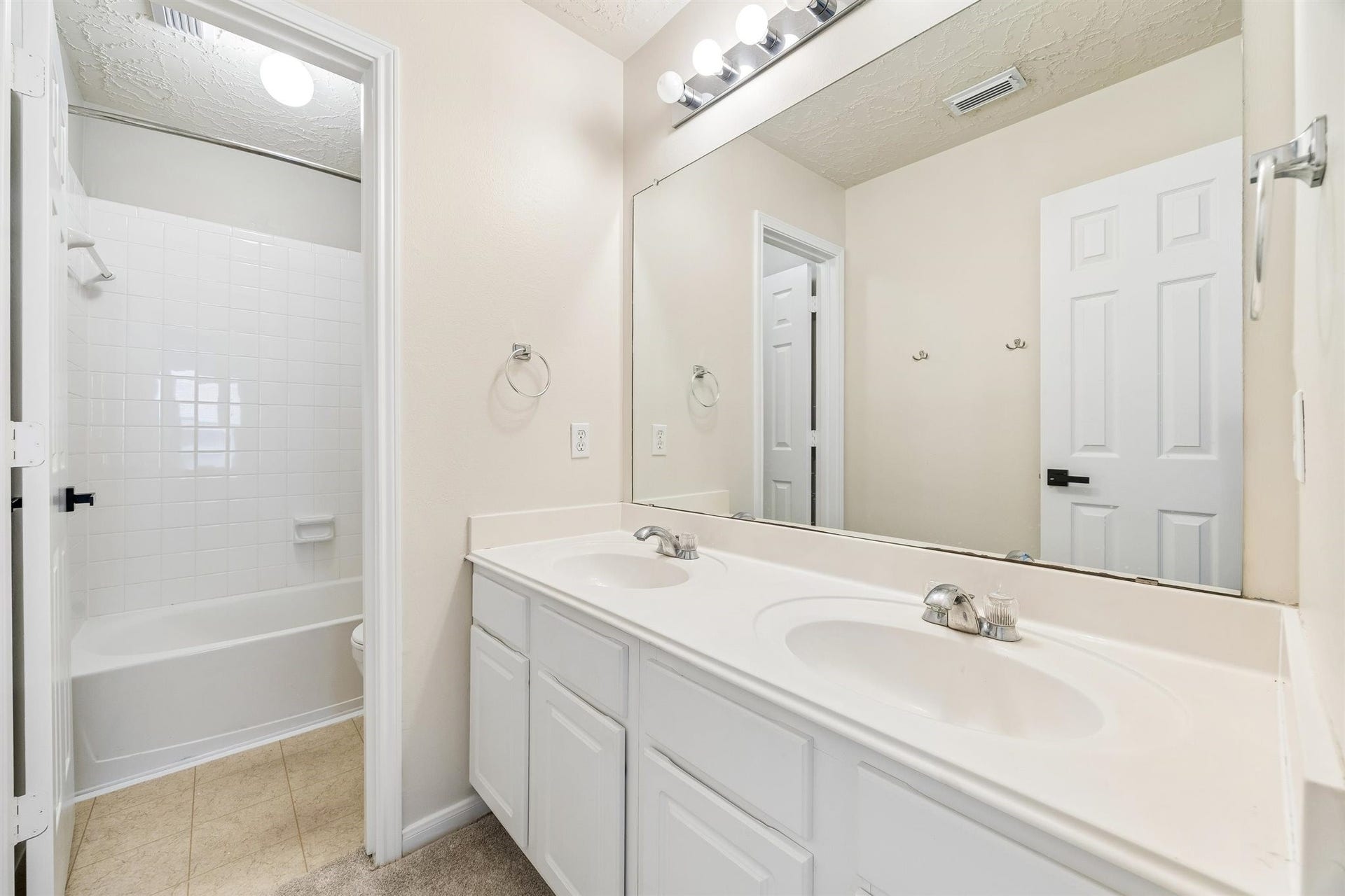 8126 BUFFALO SPRINGS COURT, Sugar Land, TX 77479 UPSTAIRS BATHROOM OFFERS A DOUBLE-SINK VANITY, EXPANSIVE MIRROR, AND TUB-SHOWER COMBINATION.