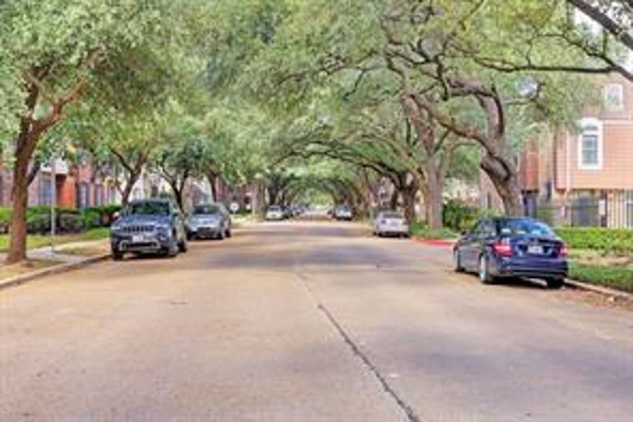 351 N Post Oak Lane, #715, Houston, TX 77024 A quiet, tree-lined residential street with parked cars and charming brick homes, offering a serene neighborhood feel.