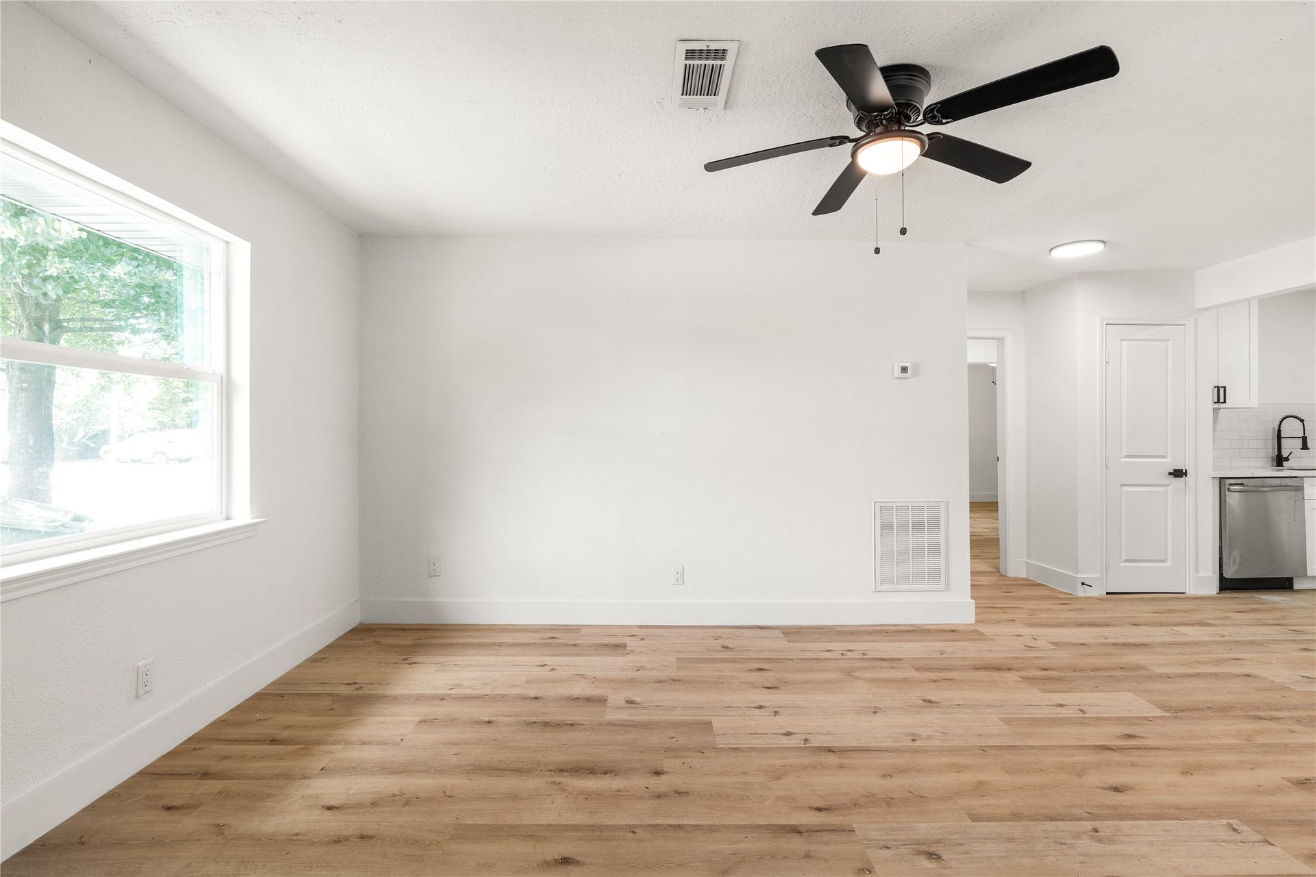 3048 Briarwick Lane, Houston, TX 77093 Expansive living space featuring rich wood-look flooring and continuous flow into the adjacent kitchen.