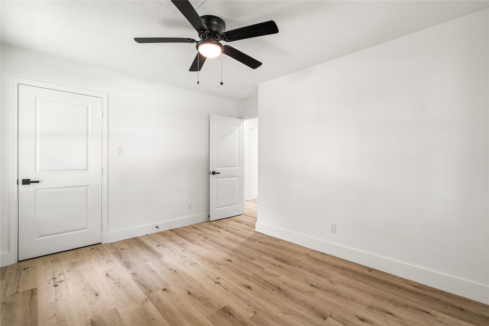 3048 Briarwick Lane, Houston, TX 77093 Reverse view of Bedroom highlighting beautiful wood-look flooring, crisp white trim, and modern door hardware.