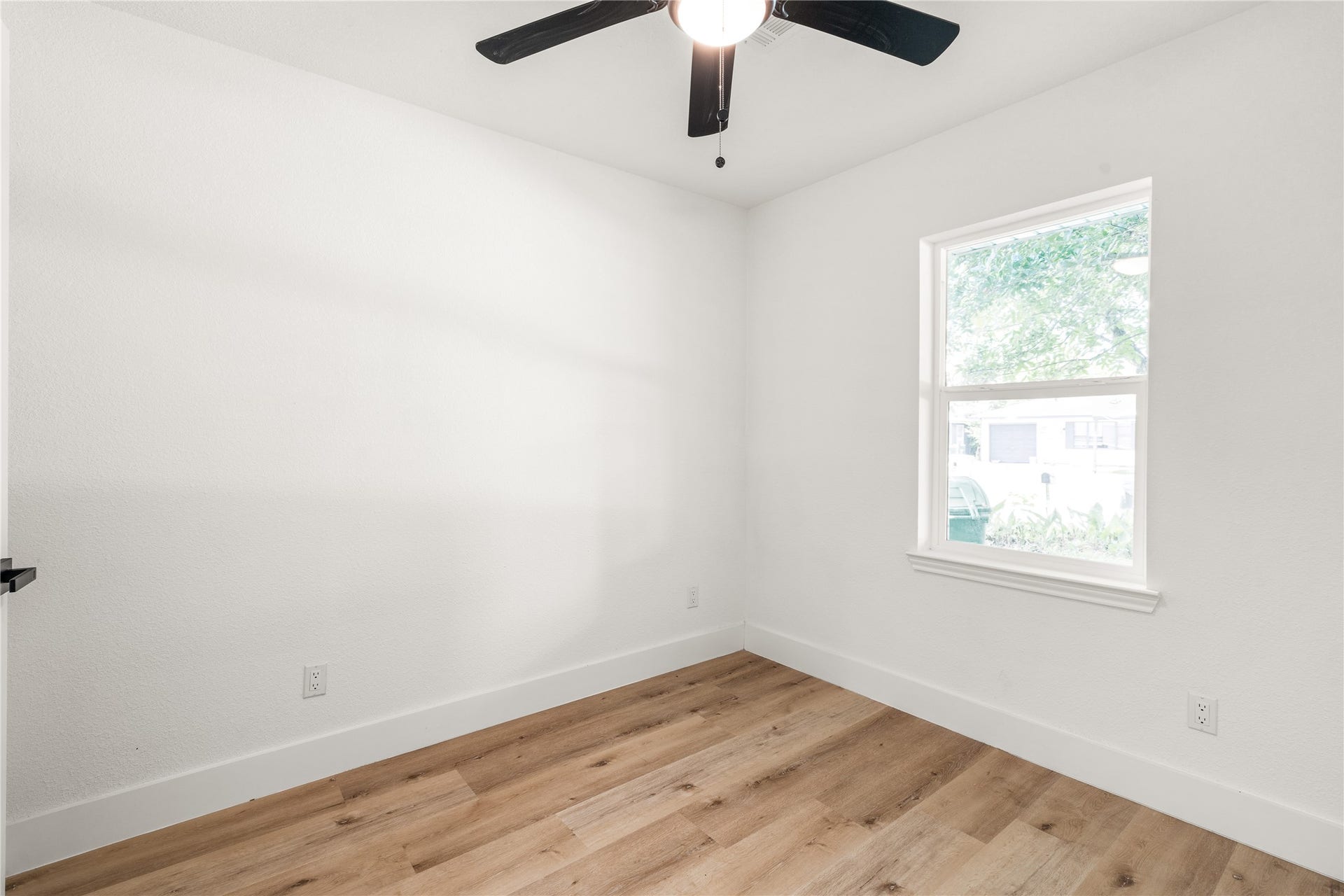3048 Briarwick Lane, Houston, TX 77093 Bright secondary bedroom showcasing crisp neutral walls, warm wood-grain flooring, and lovely natural light.