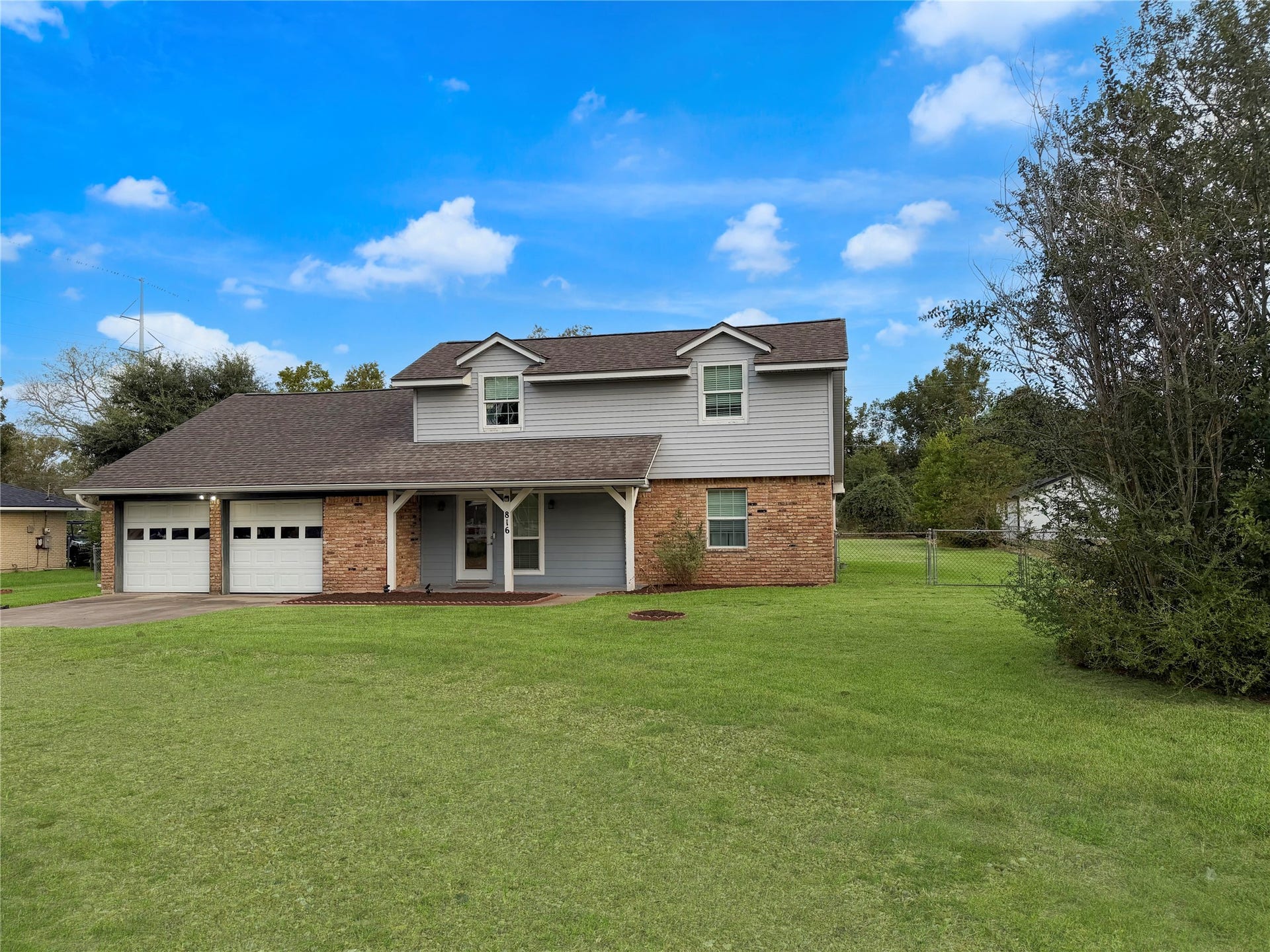 816 W Mulberry, Angleton, TX 77515 Charming two-story home featuring a small covered front porch, welcoming entryway, and appealing exterior design