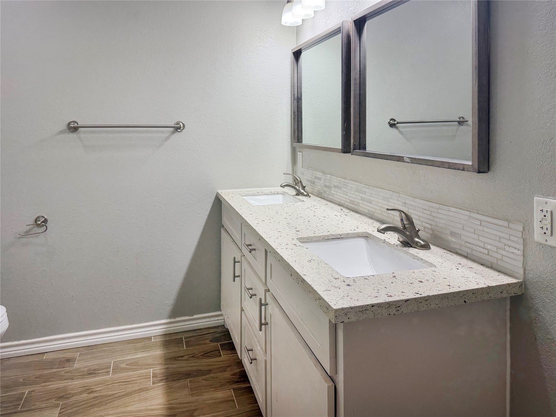 816 W Mulberry, Angleton, TX 77515 Primary bathroom features a double-sink vanity with white cabinetry, offering convenient counter space and storage for everyday essentials.