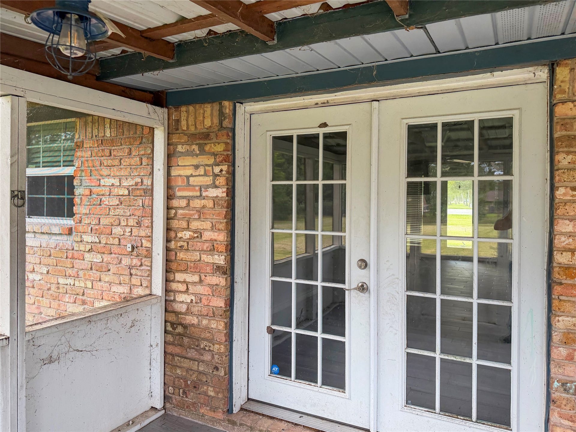 816 W Mulberry, Angleton, TX 77515 Small screened-in back porch features double doors leading into the home, offering a comfortable space to relax and enjoy the outdoors.