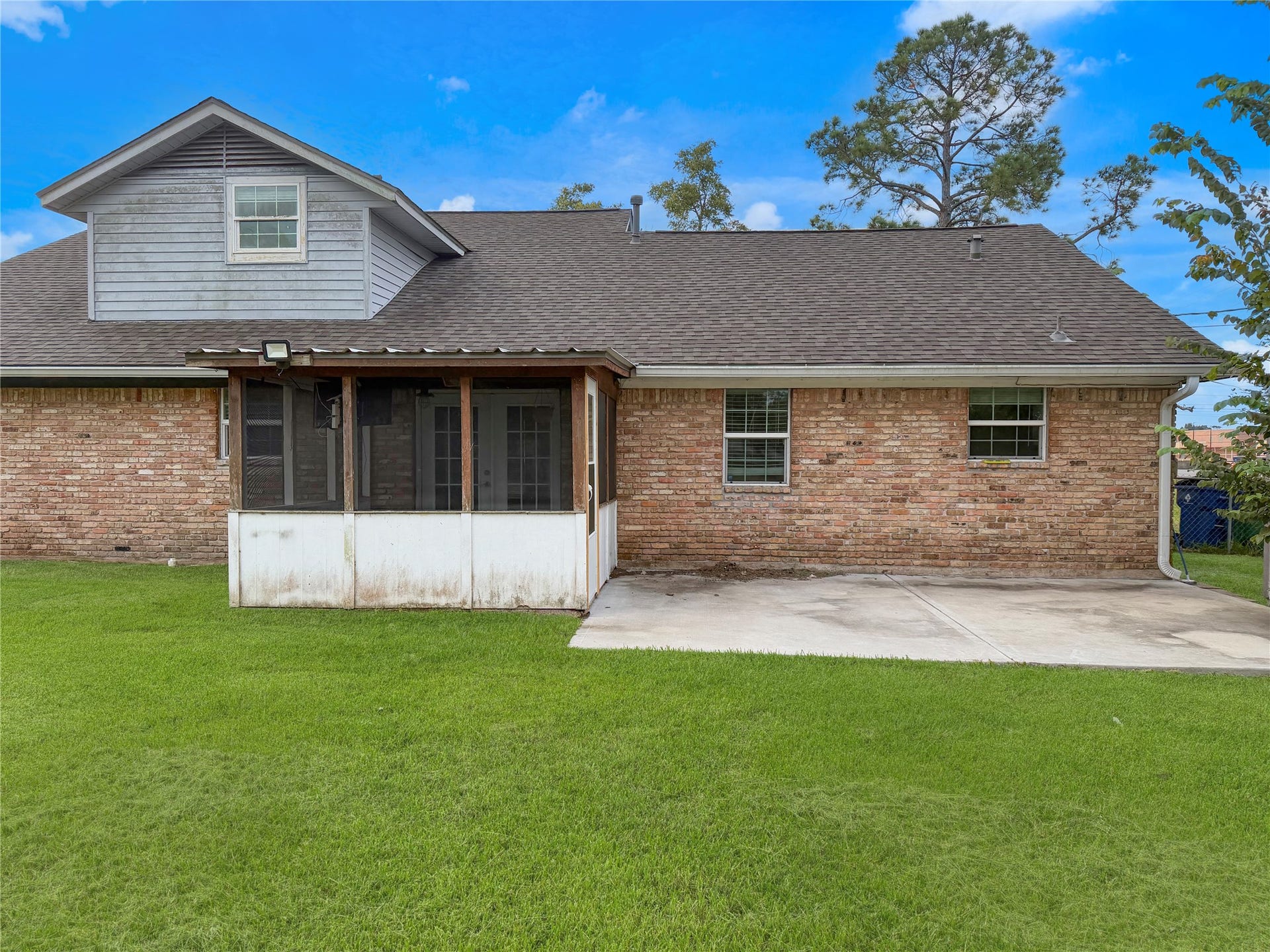 816 W Mulberry, Angleton, TX 77515 Screened-in back porch provides a comfortable space to enjoy the outdoors, while the adjacent concrete slab offers additional room for grilling, seating, or relaxing.