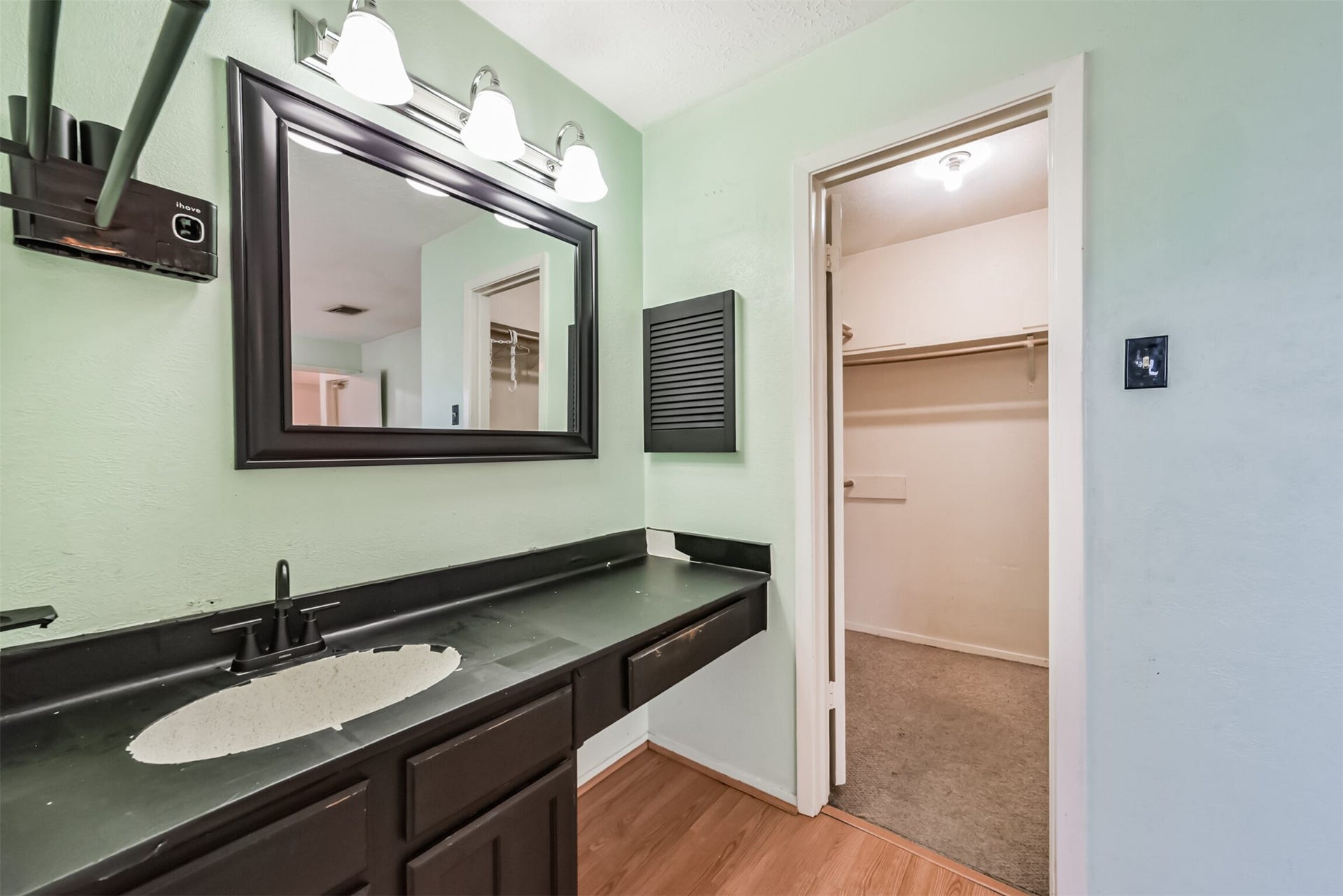 16510 Quiet Quail Drive, Houston, TX 77489 Modern bathroom with a sleek black countertop, stylish mirror, and ample cabinet space, leading to a spacious walk-in closet.
