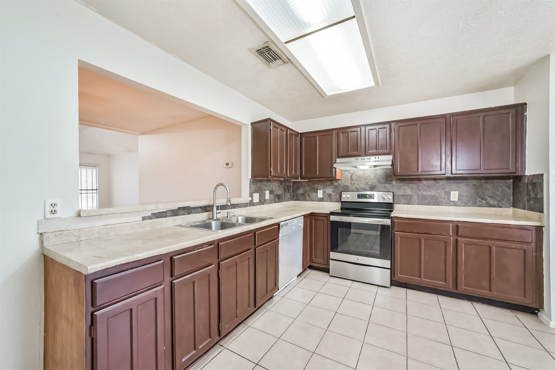 16510 Quiet Quail Drive, Houston, TX 77489 Spacious kitchen with rich wood cabinetry, sleek stainless steel appliances, and ample counter space, perfect for culinary enthusiasts.