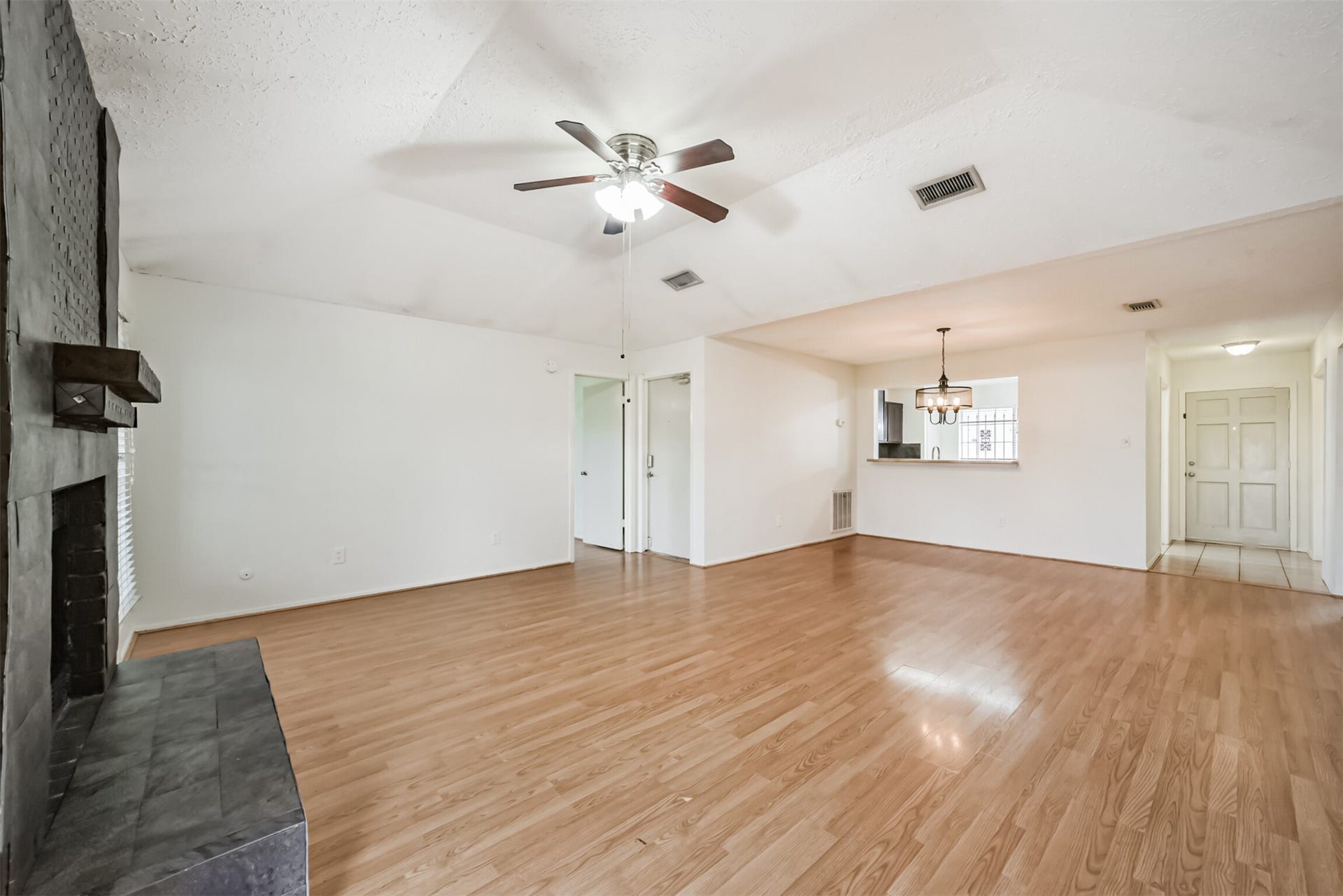 16510 Quiet Quail Drive, Houston, TX 77489 Spacious living area featuring elegant hardwood floors, a cozy fireplace, and an open layout with a ceiling fan for comfort.