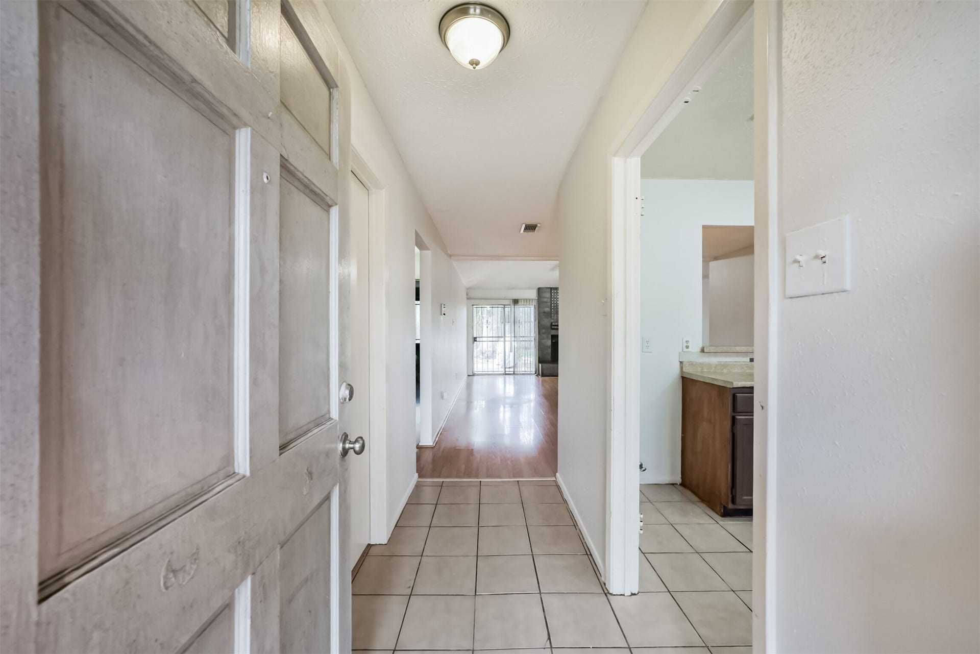 16510 Quiet Quail Drive, Houston, TX 77489 Inviting entryway with tile flooring leads to a bright, open hallway, seamlessly connecting to the living area and kitchen.