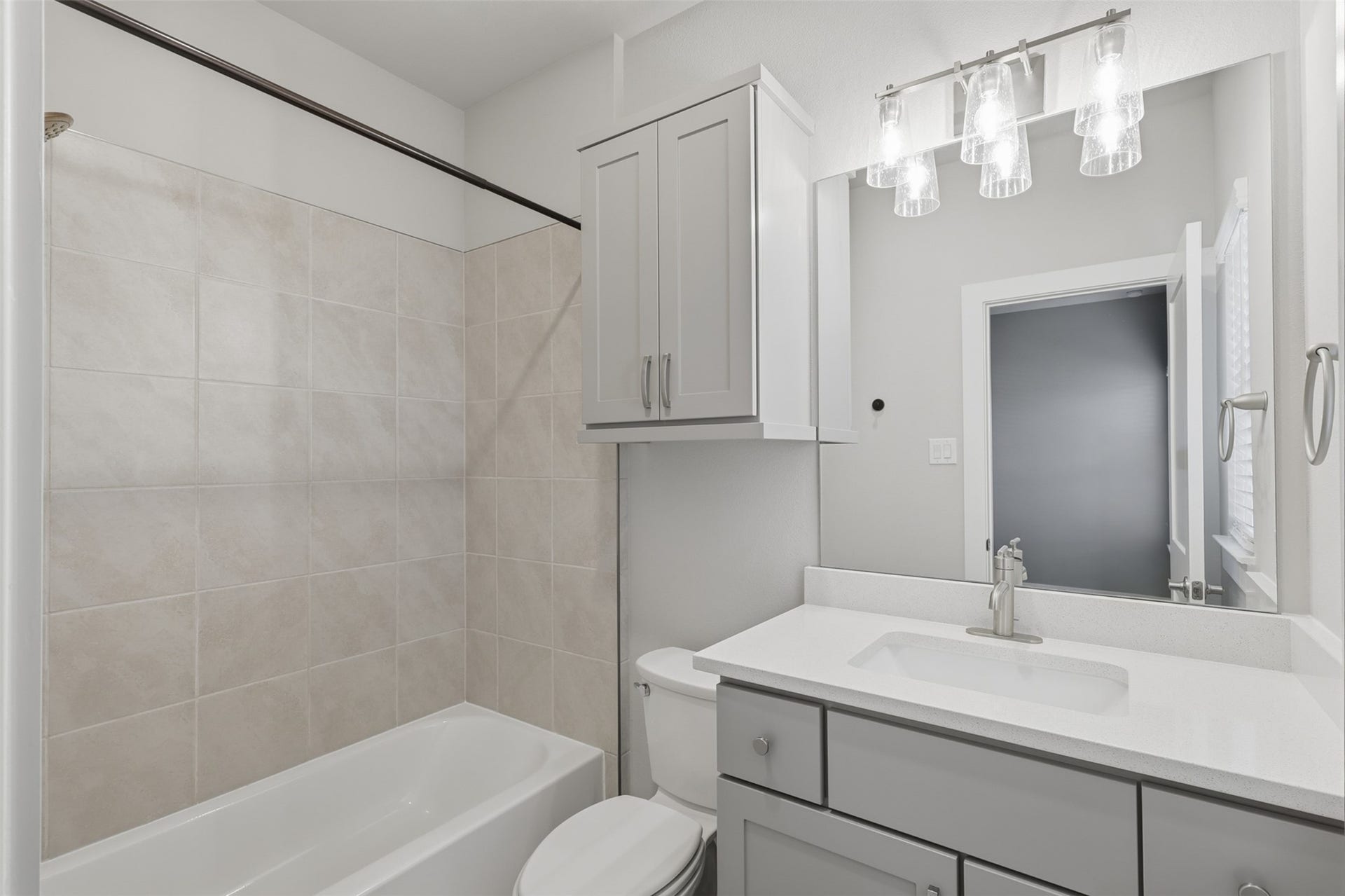 1444 W 34th 1/2 Street, Houston, TX 77018 The third-floor secondary bath features a quartz-topped vanity, modern cabinetry, and a full tub/shower combination with clean contemporary finishes.