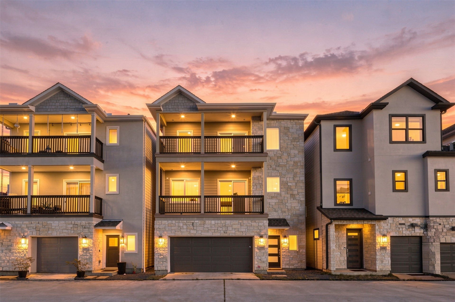 1444 W 34th 1/2 Street, Houston, TX 77018 Striking three-story exterior with stone accents, warm architectural lighting, and two spacious balconies that extend the living space outdoors.
