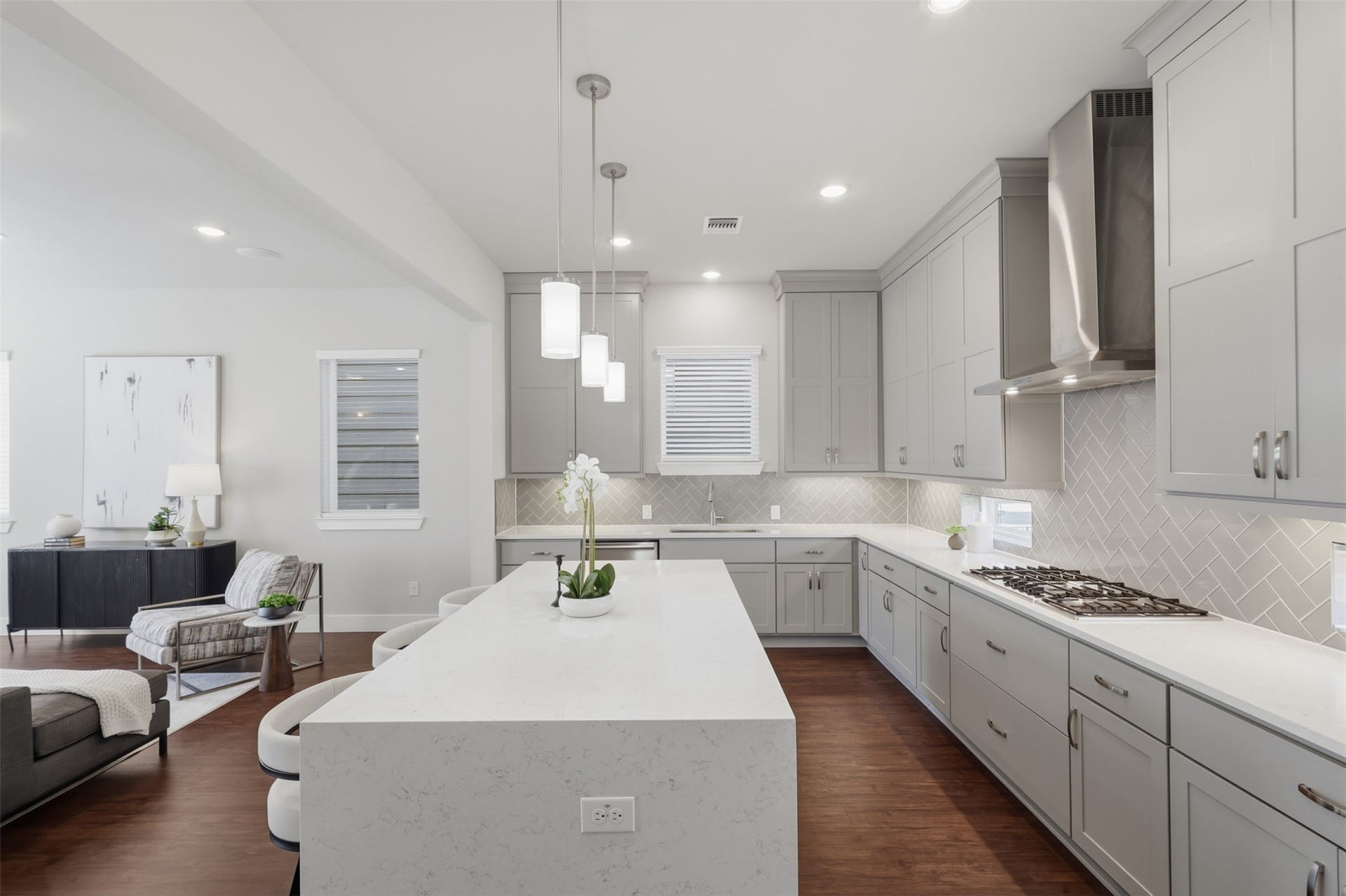 1444 W 34th 1/2 Street, Houston, TX 77018 Another view of kitchen highlights the impressive scale of the quartz waterfall island, extensive custom cabinetry, gas cooktop, and open connection to the living space.