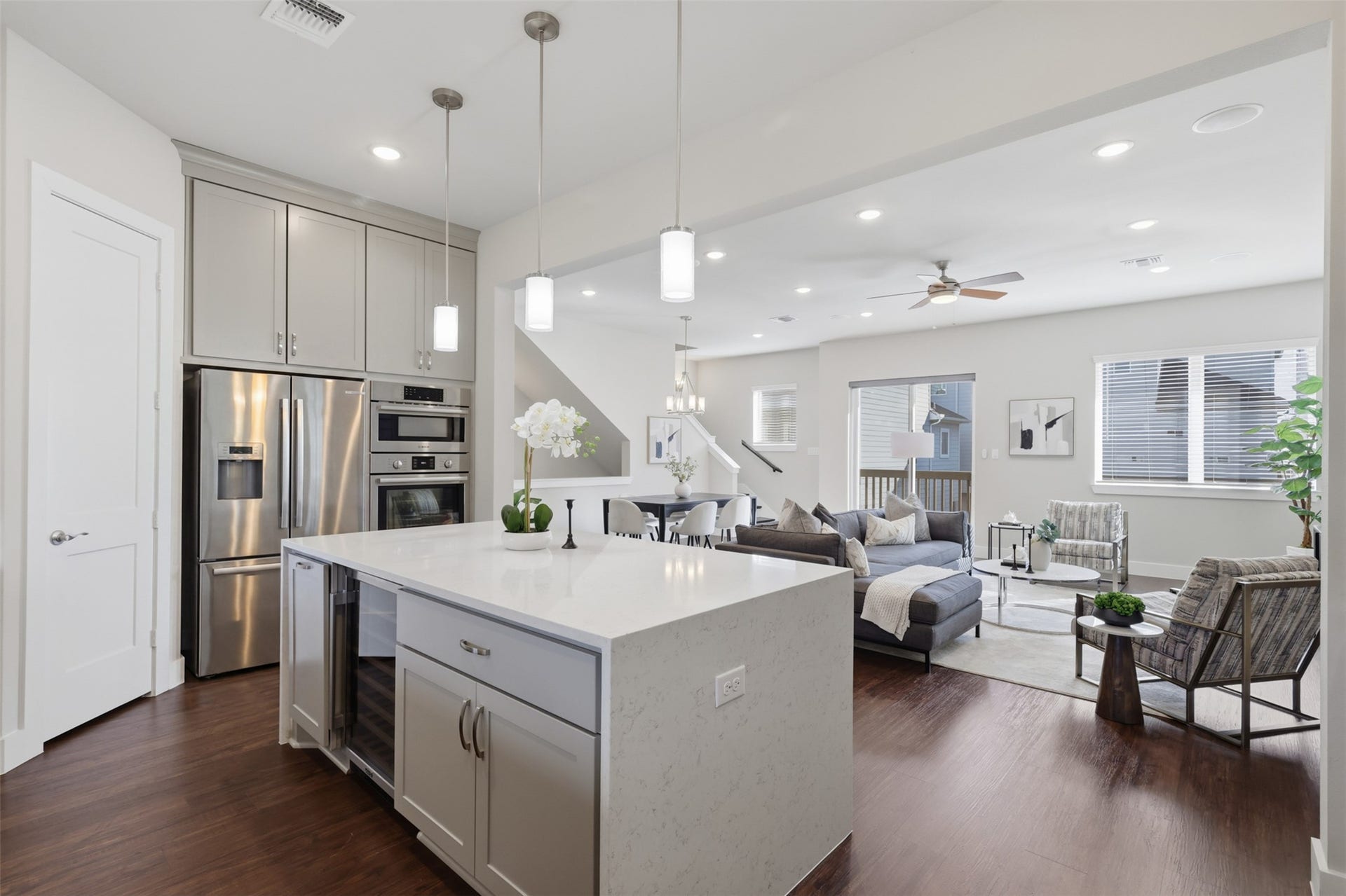 1444 W 34th 1/2 Street, Houston, TX 77018 A closer look at the kitchen showcases the oversized quartz waterfall island, built-in wine refrigerator, and clean sightlines across the main living area.