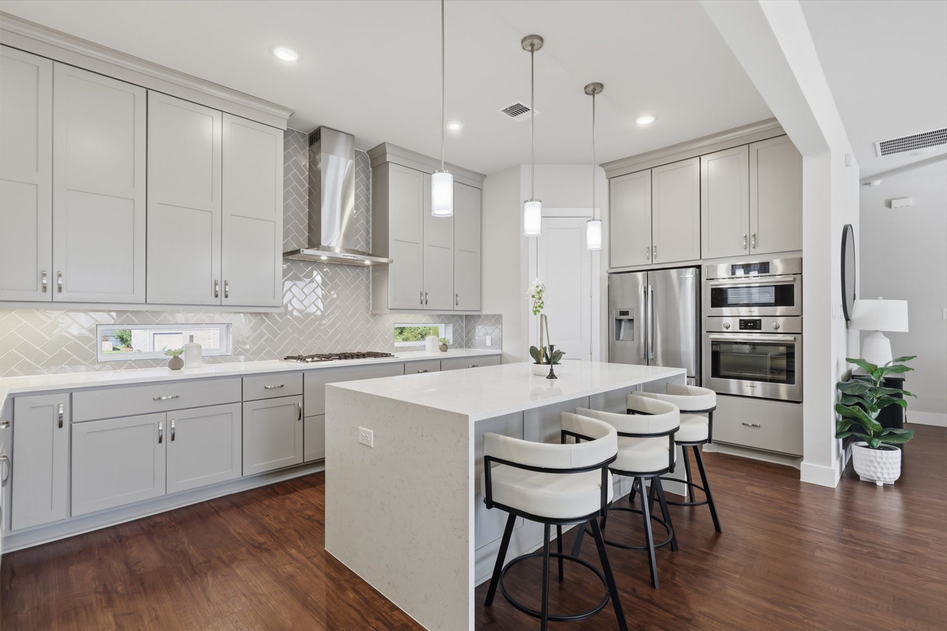 1444 W 34th 1/2 Street, Houston, TX 77018 The kitchen is one of the standout upgrades in the home, featuring custom Kent Moore cabinetry extending to the ceiling, Bosch appliances, and a sleek herringbone backsplash.