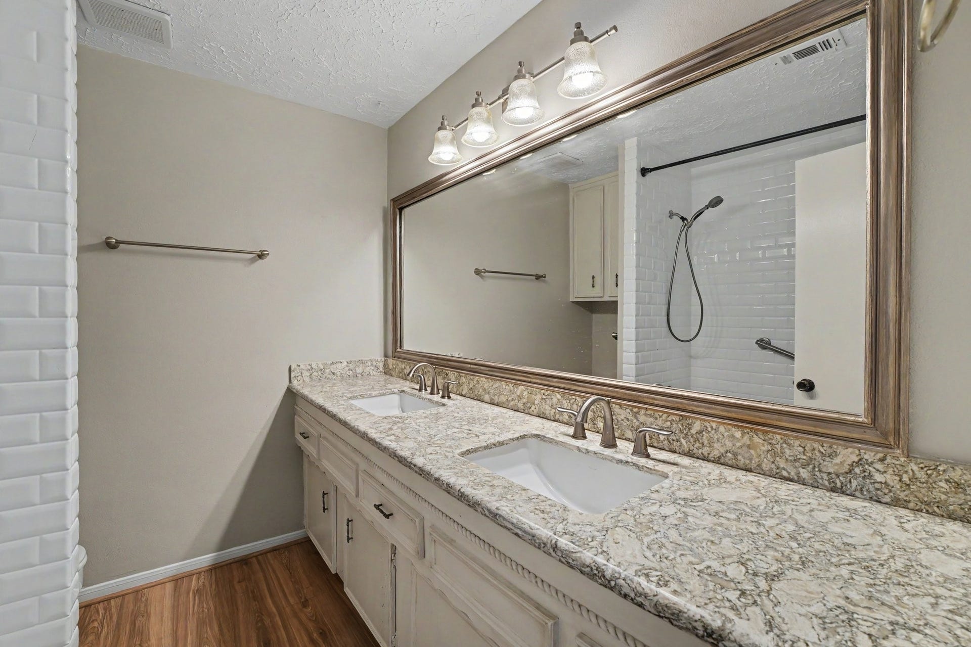 44 Chapparal Court, Missouri City, TX 77459 This well-appointed upper-level full bathroom features an expansive double-sink vanity topped with elegant granite counters and brushed nickel faucets, perfect for streamlining busy mornings.