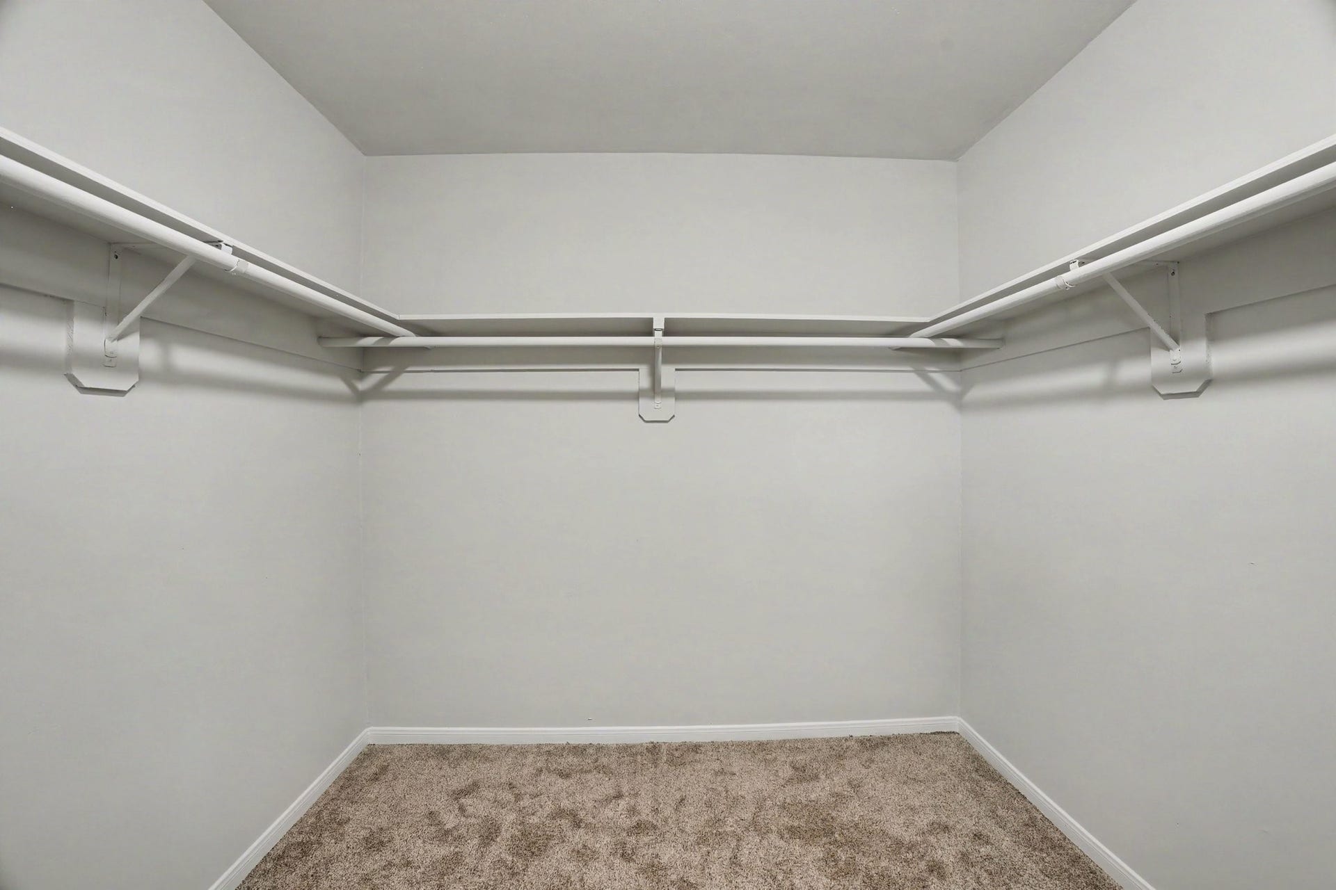 44 Chapparal Court, Missouri City, TX 77459 This spacious walk-in closet offers exceptional storage capacity and organization. Built-in wrap-around shelving and double clothing rods span across three walls, maximizing vertical and horizontal space for hanging attire, storing folded items, and organizing accessories.