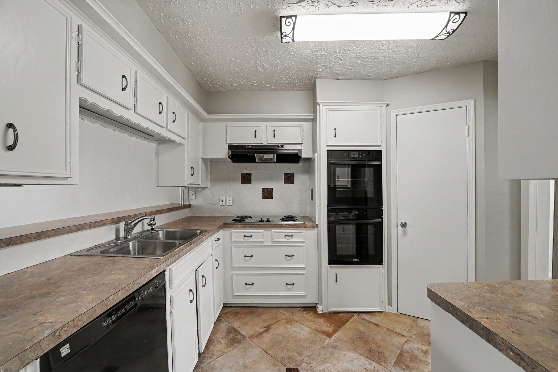 44 Chapparal Court, Missouri City, TX 77459 A deep double sink sits under a convenient pass-through window that keeps the room connected to adjoining living spaces while maximizing light.