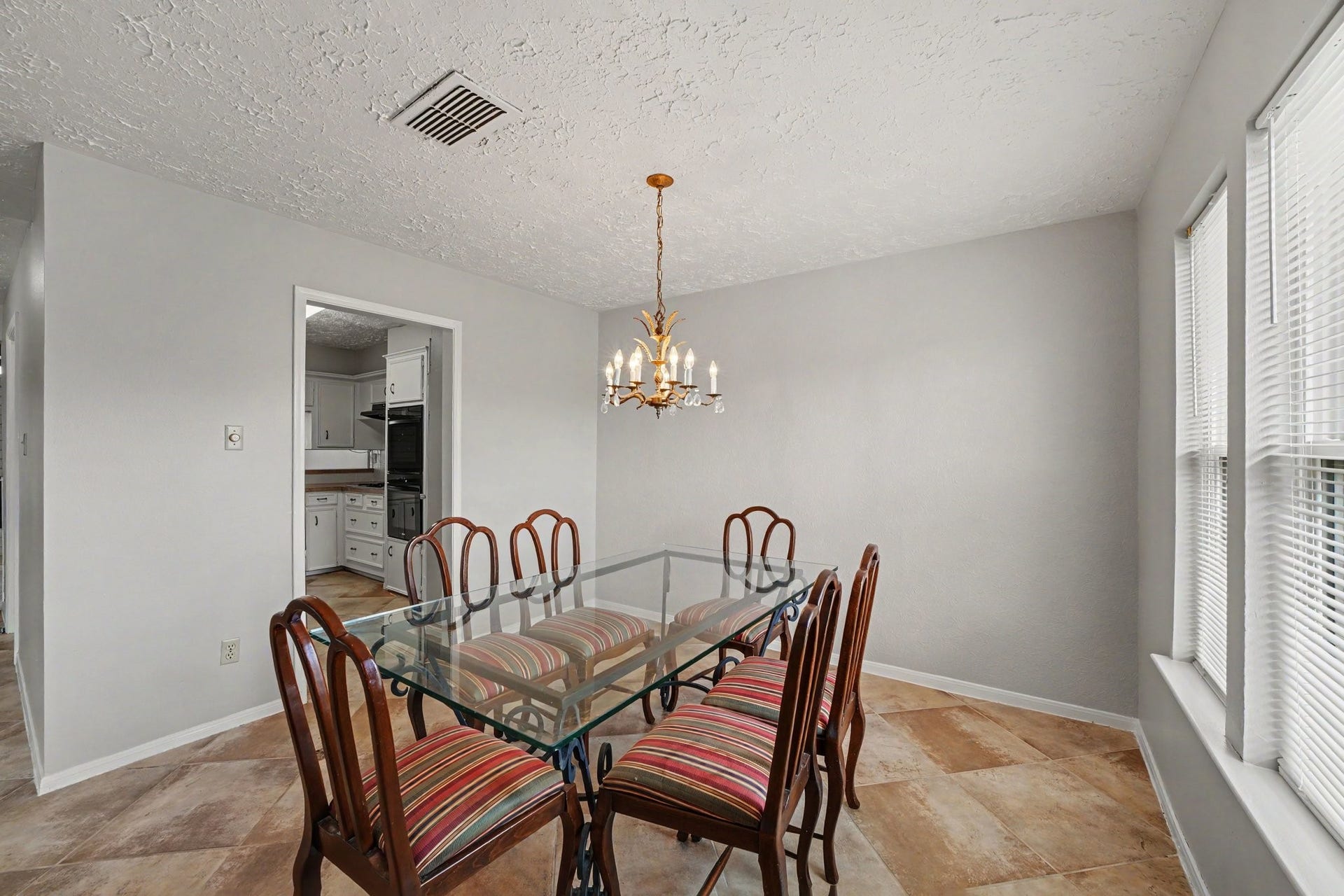 44 Chapparal Court, Missouri City, TX 77459 The homes dedicated dining area offers a cozy yet elegant setting for entertaining and everyday meals, anchored by a traditional brass chandelier that casts a soft, welcoming glow over the room.