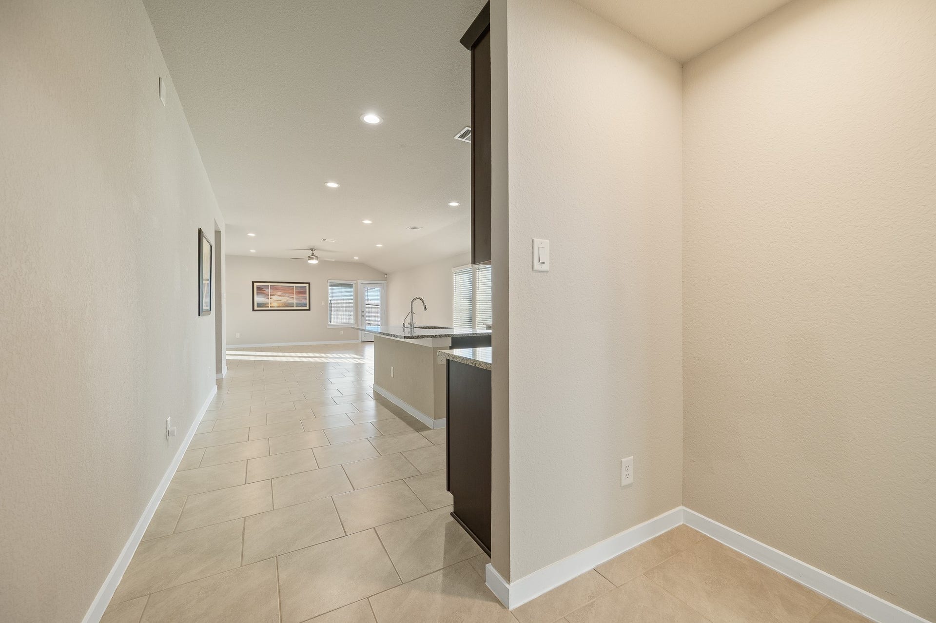 This bright and welcoming entryway features high ceilings, polished tile flooring, offering a glimpse of the open layout and modern design.
