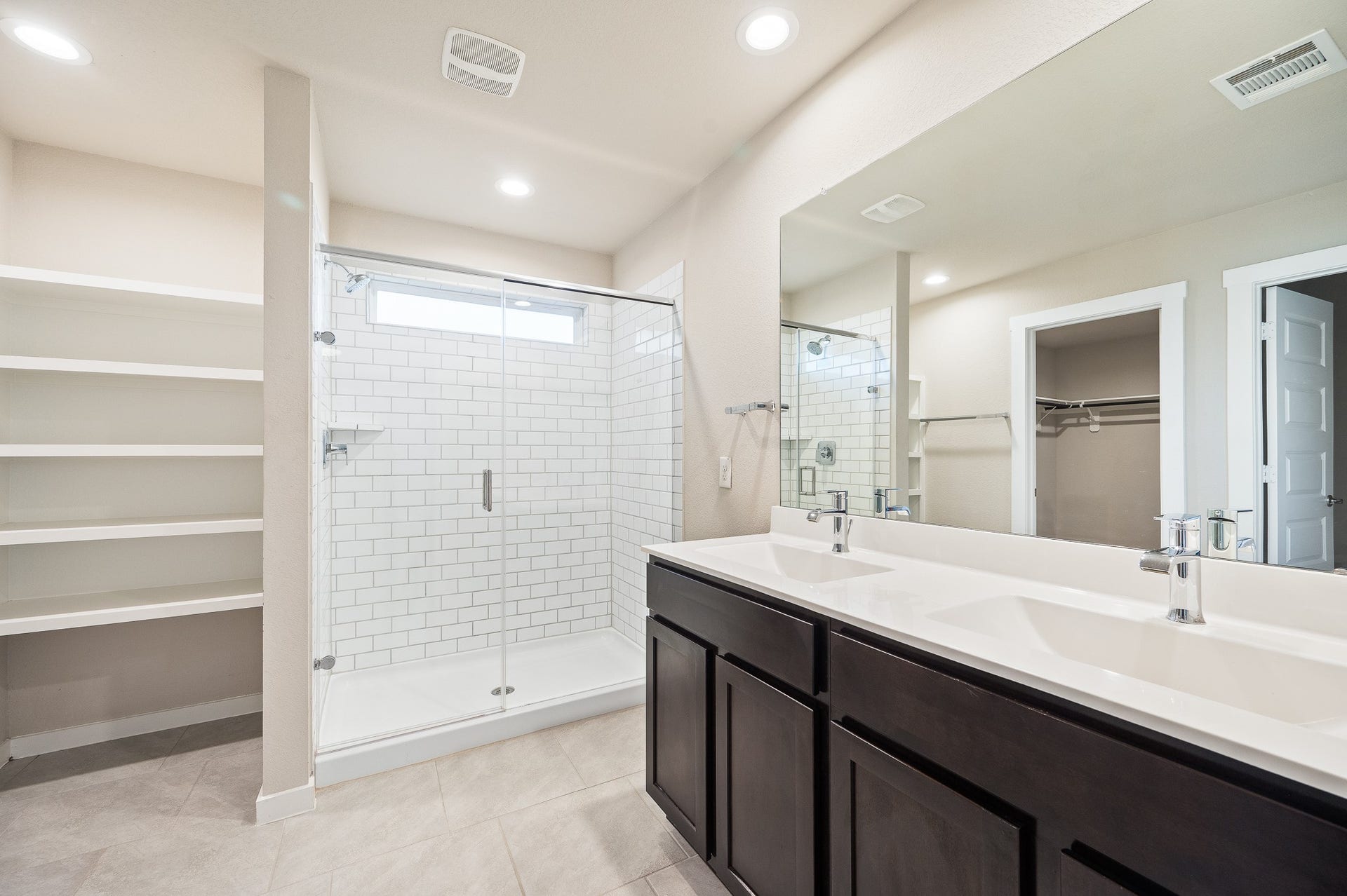 Thoughtfully designed, luxurious ensuite primary bath with double sink and huge walk-in closet.
