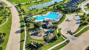 A suburban neighborhood with neatly arranged, modern homes featuring spacious yards. The streets are wide and well-maintained, with sidewalks and trees lining the area. The community is peaceful and well-organized, ideal for family living.