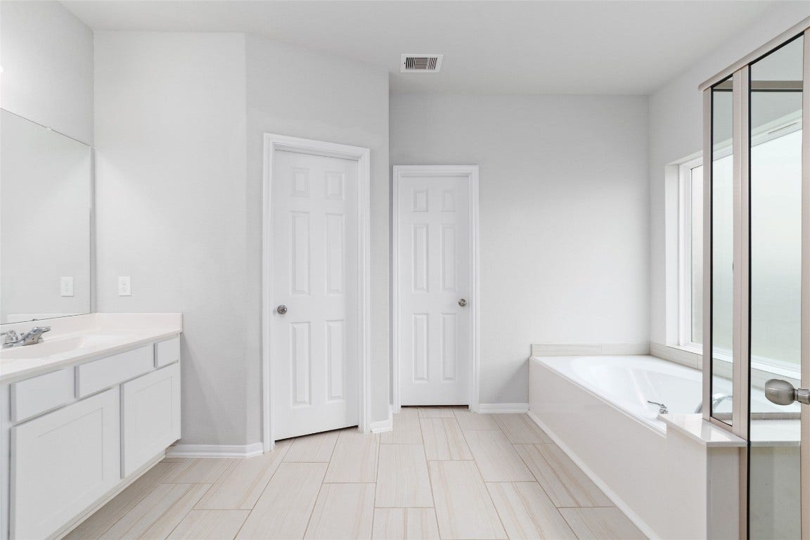 20755 Beeston Glade Lane, Katy, TX 77449 Primary bathroom with dual vanity, closets, soaking tub and walk in shower