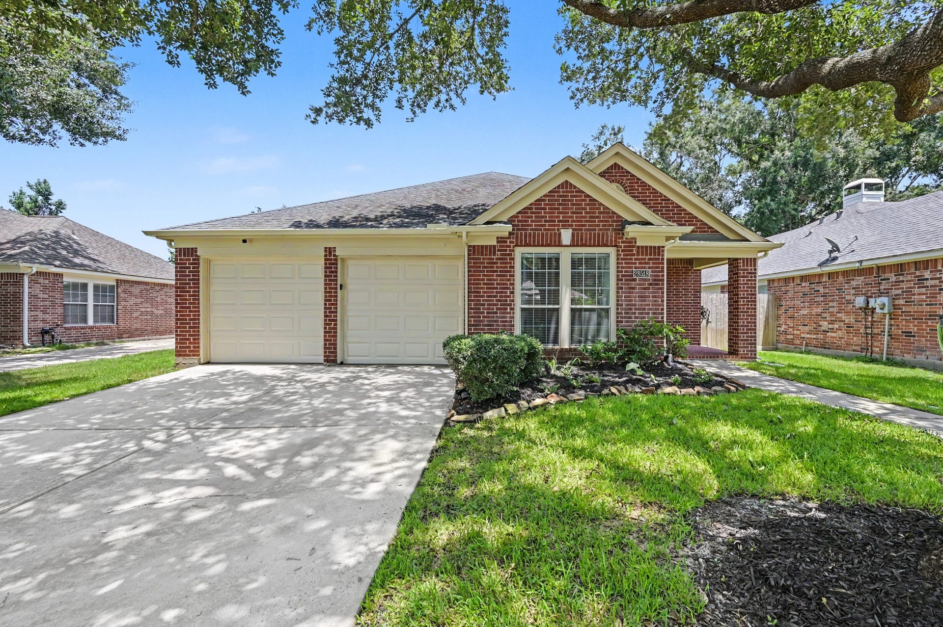 Welcome home to 28518 Ashlyn Ridge Lane, where mature trees frame the driveway and give you a shady, inviting arrival before you even step inside.