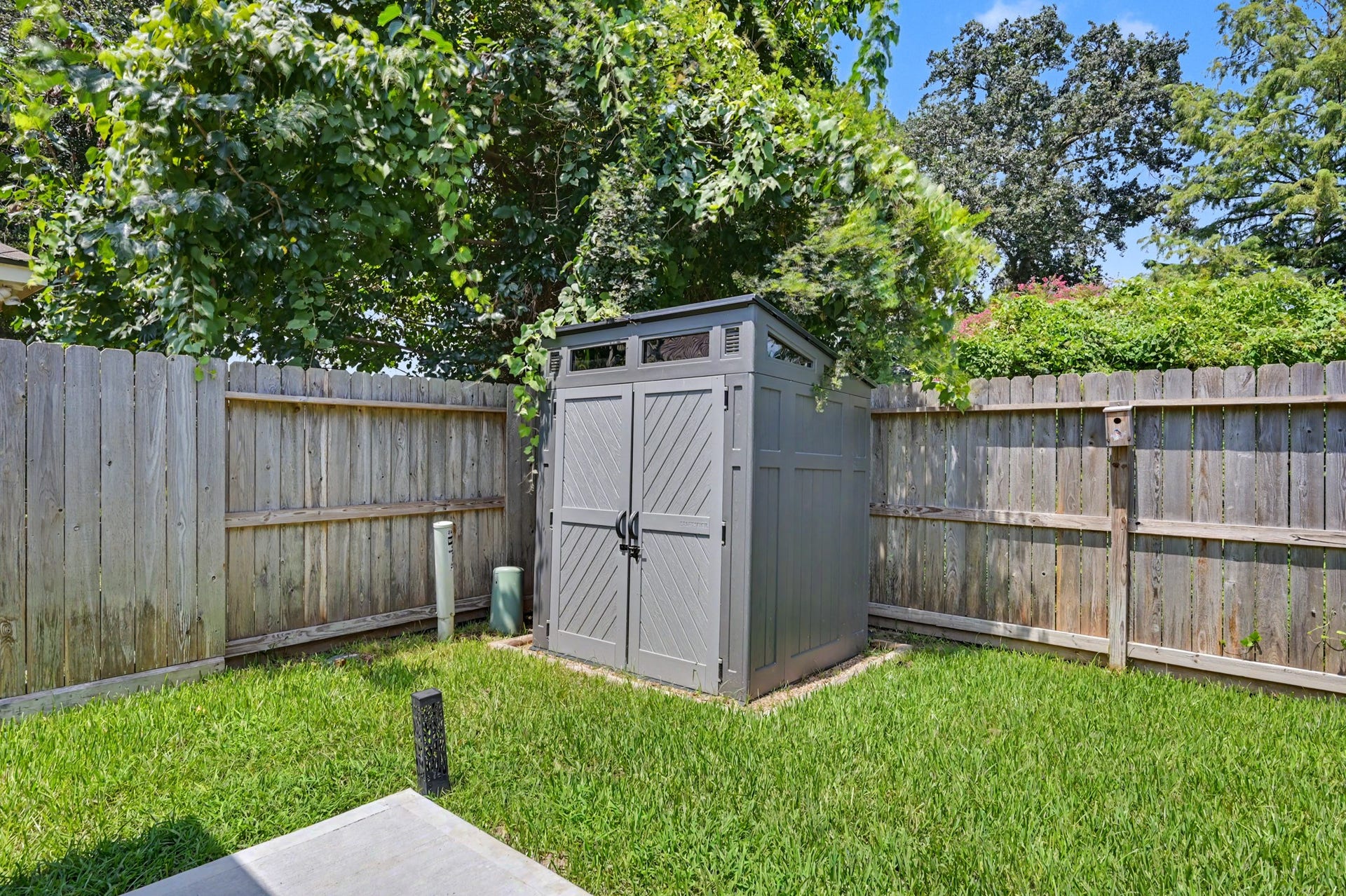 A backyard storage shed keeps lawn equipment, seasonal decorations, and outdoor toys safely tucked away instead of taking over your garage.