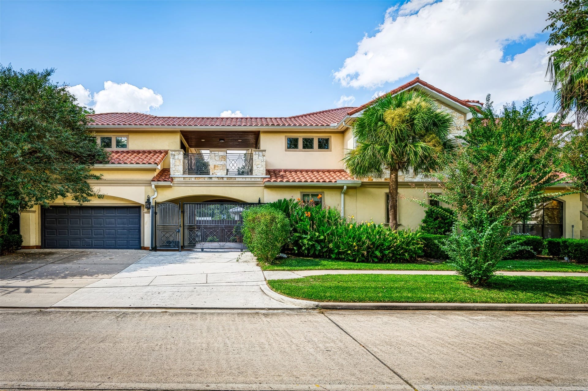 The side of the home has an extra-large driveway space, a 2-car garage, and an automatic gate that opens to the courtyard in the back of the home.
