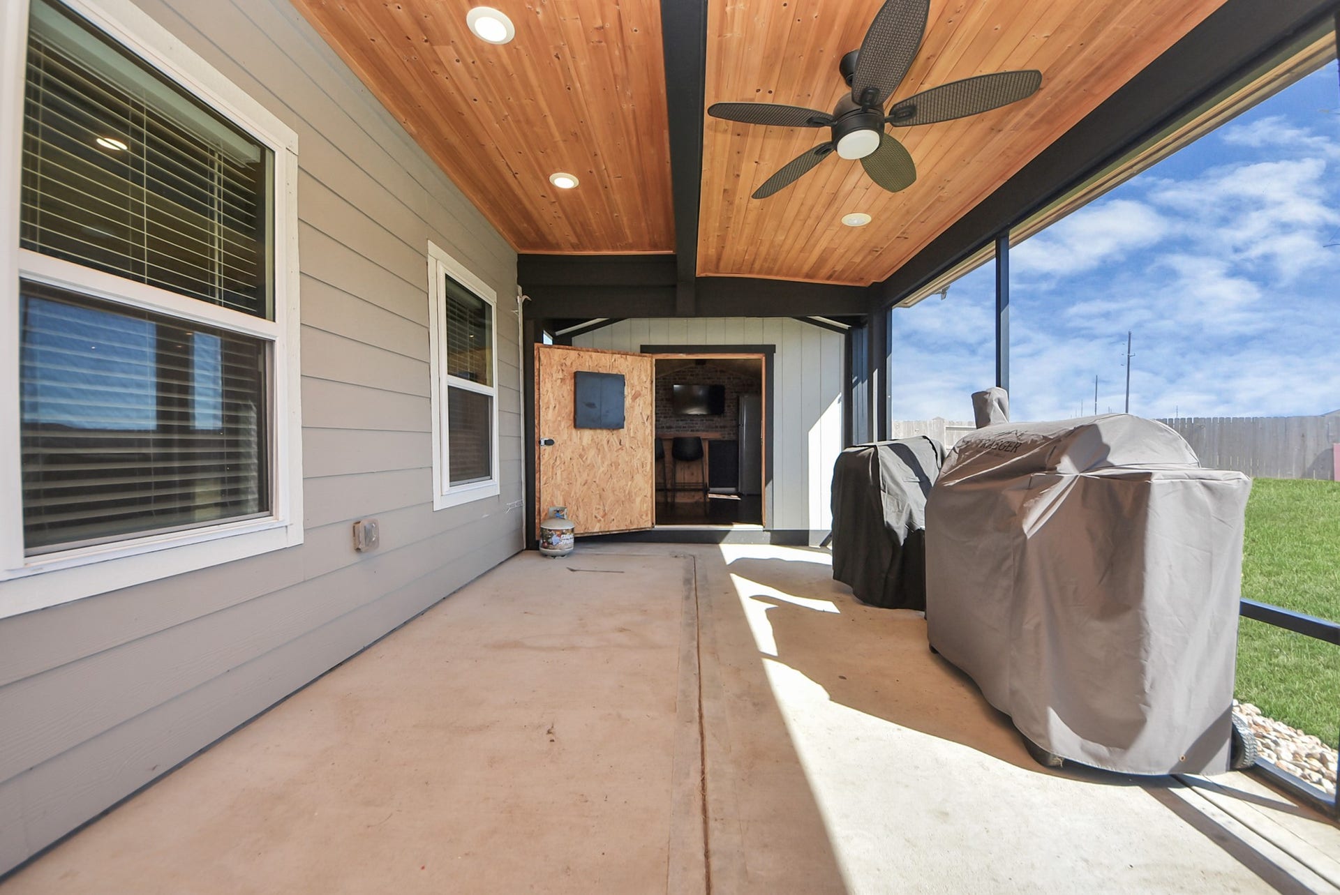 930 Pismo Lane, Rosharon, TX 77583 Screened in and covered patio with a wood-paneled ceiling and recessed lighting, features a ceiling fan, and access to the bar. Great spot for grilling and enjoying the outdoors without bugs.