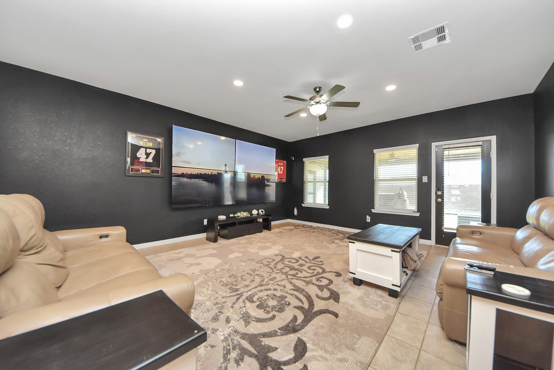 930 Pismo Lane, Rosharon, TX 77583 Spacious living room featuring ample natural light from two windows, and a door leading to enclosed outside patio. Ideal for entertainment and relaxation.