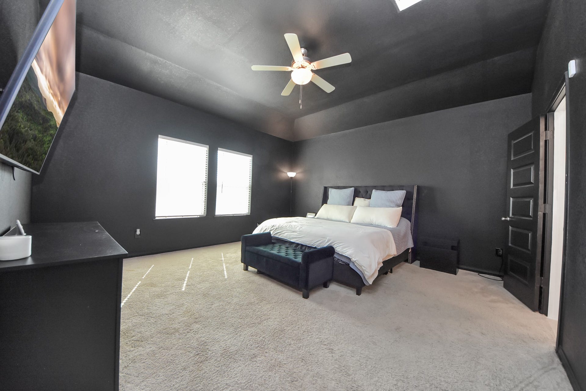 930 Pismo Lane, Rosharon, TX 77583 Spacious primary bedroom with dramatic, moody ambiance features a vaulted ceiling and ceiling fan.