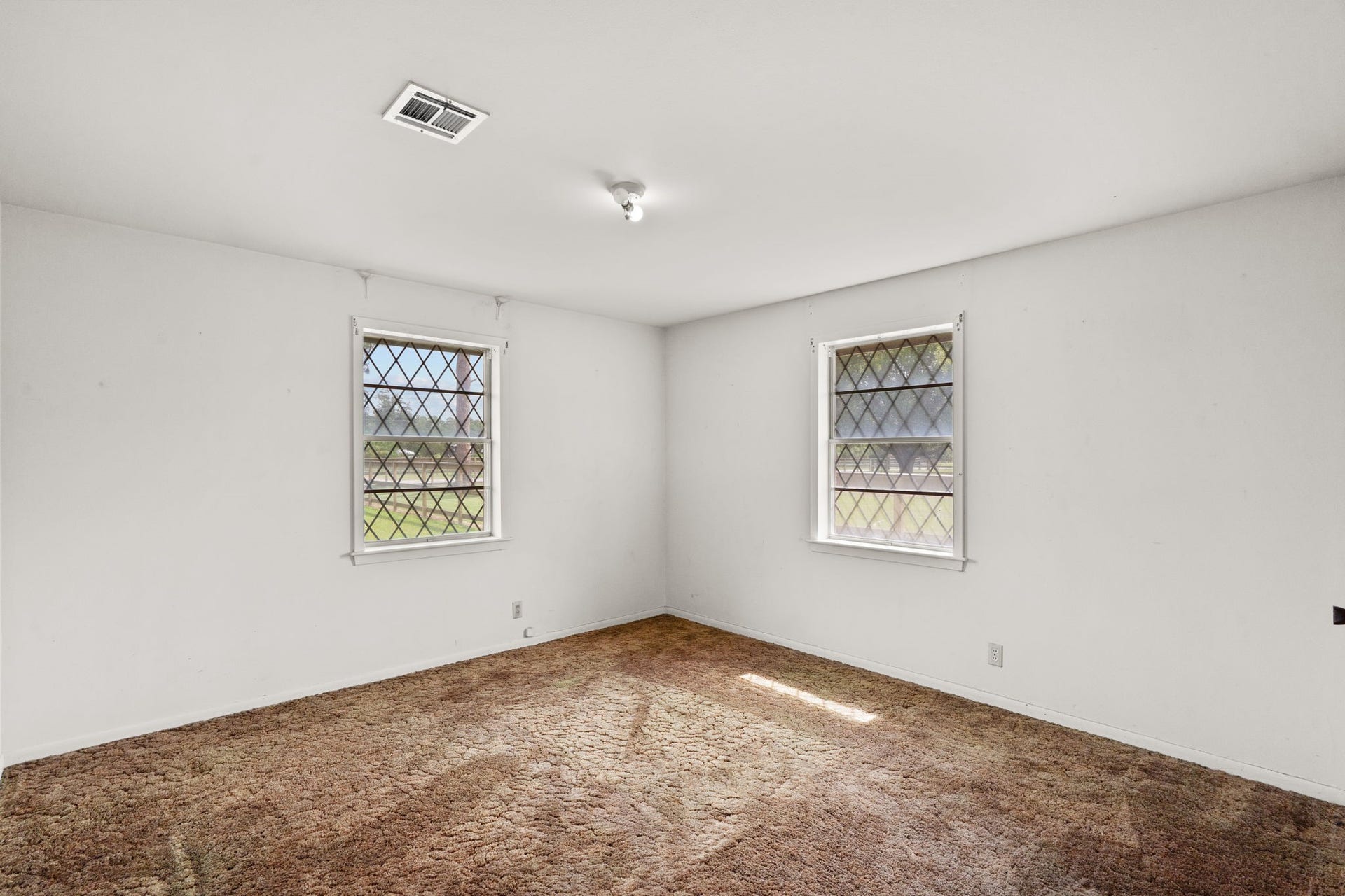 8218 Avenue M, Santa Fe, TX 77510 Bedroom with two windows and neutral walls.
