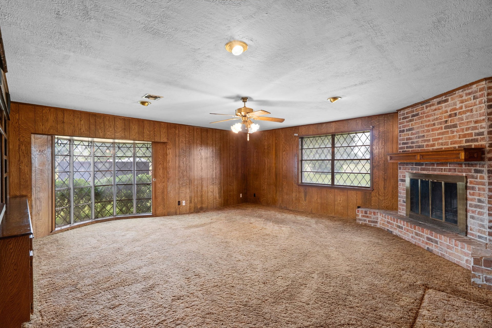8218 Avenue M, Santa Fe, TX 77510 Family room with brick fireplace and large windows.