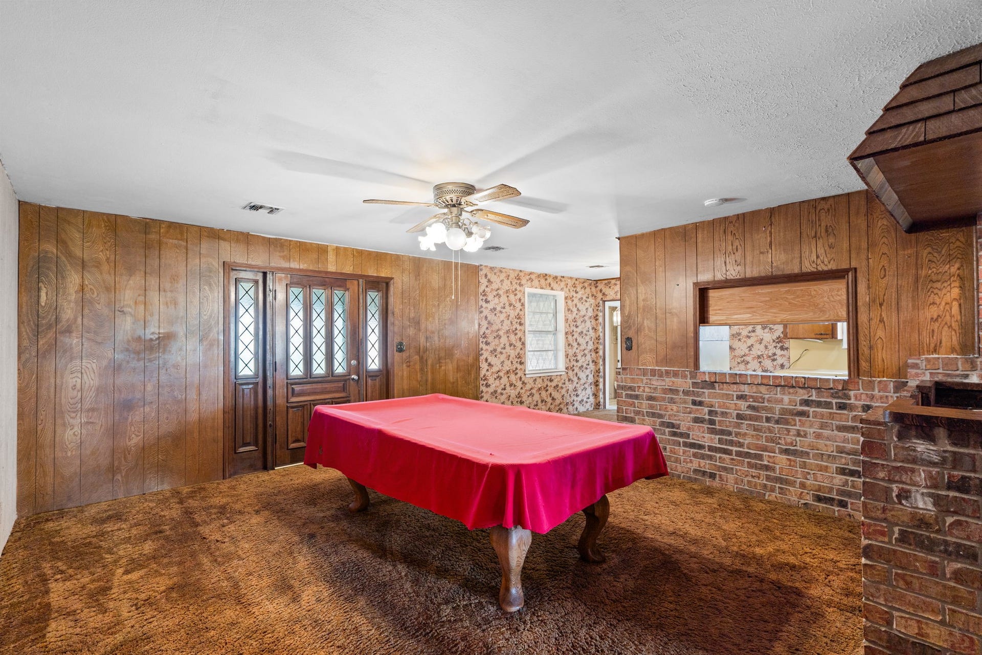 8218 Avenue M, Santa Fe, TX 77510 Entertainment/living space with wood paneling and custom wet bar.