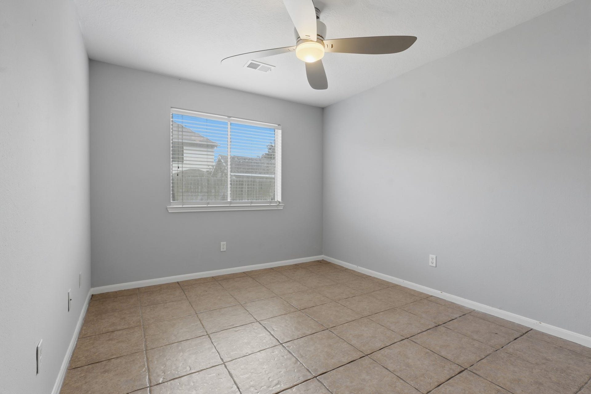 1242 Hunter Wood Drive, League City, TX 77573 Versatile secondary bedroom with tile flooring, ceiling fan and neutral finishes.